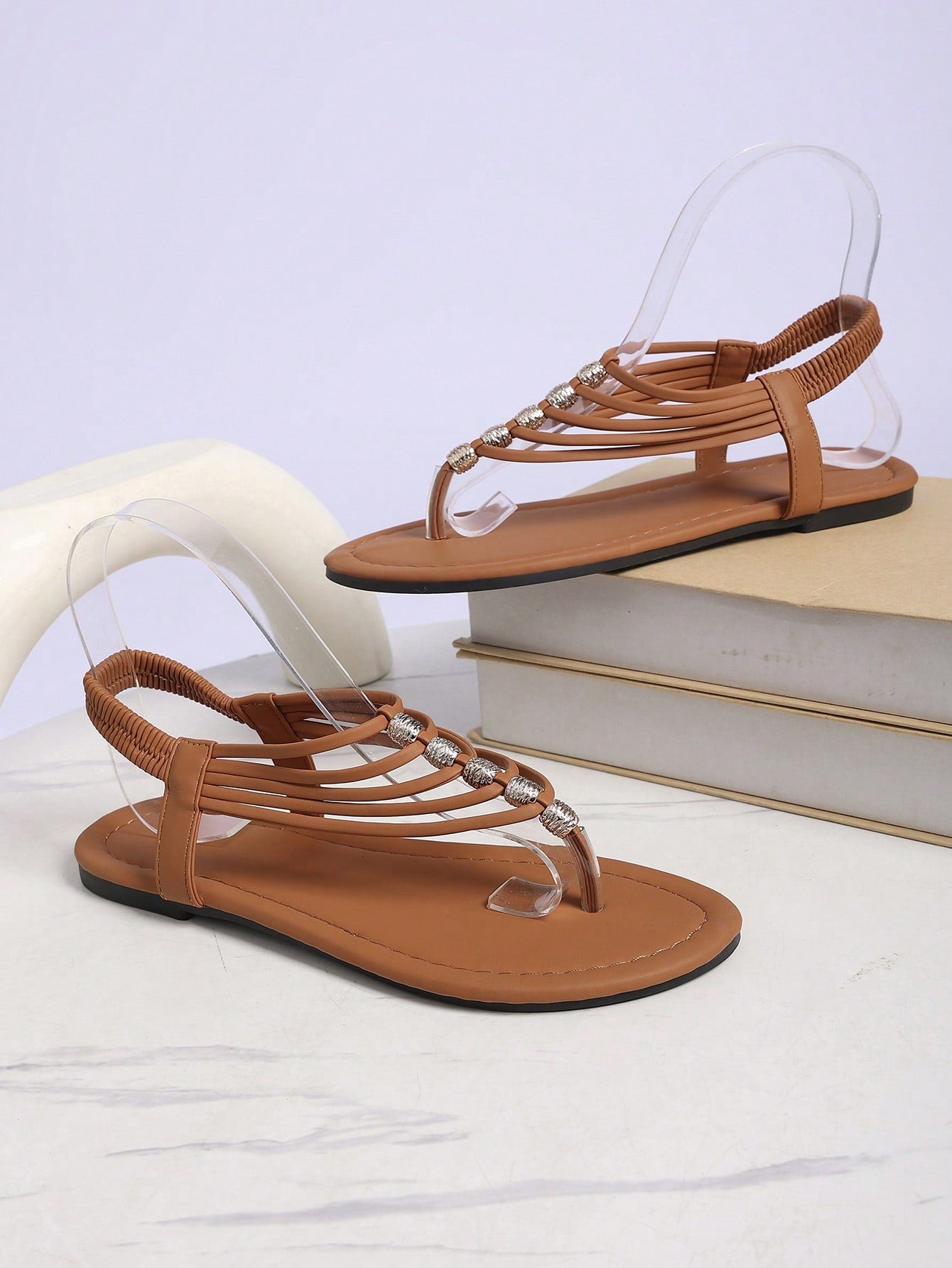 Women's boho flat sandals with elastic straps, braided beaded criss-cross detail, and toe post in gladiator style, suitable for beach, party, and outdoor summer wear.