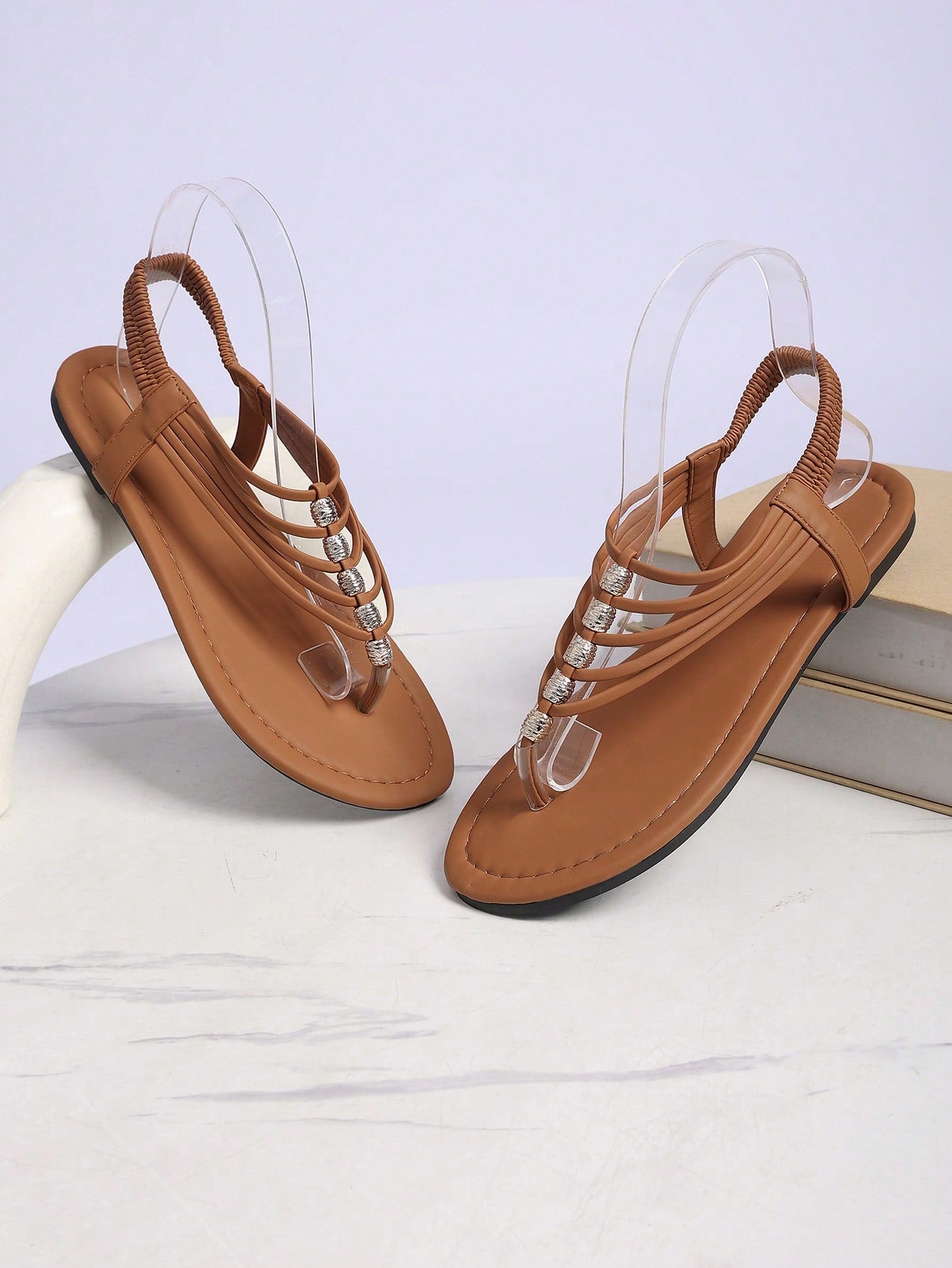 Women's boho flat sandals with elastic straps, braided beaded criss-cross detail, and toe post in gladiator style, suitable for beach, party, and outdoor summer wear.