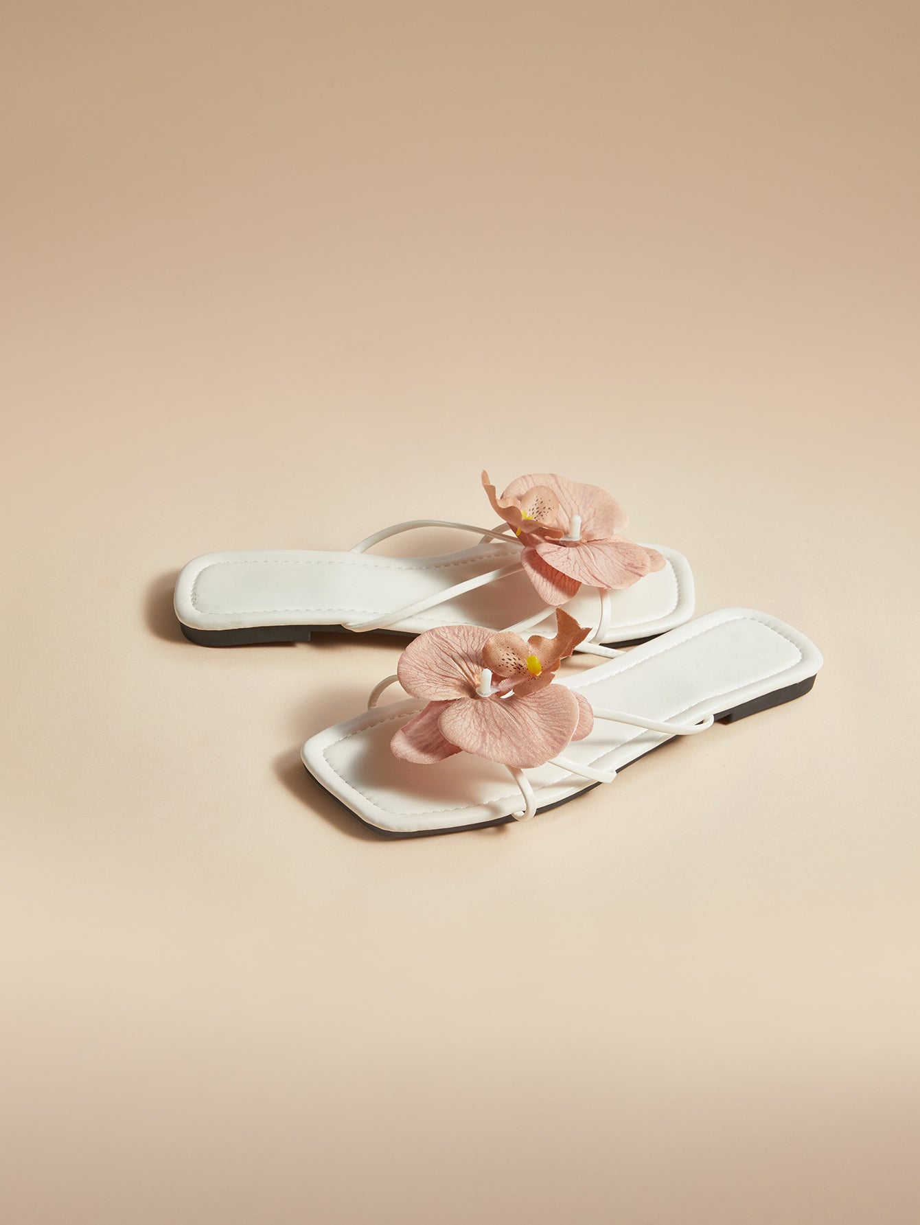 Brown women's flat slide sandals with floral applique strap and plant-inspired design, suitable for outdoor summer wear.