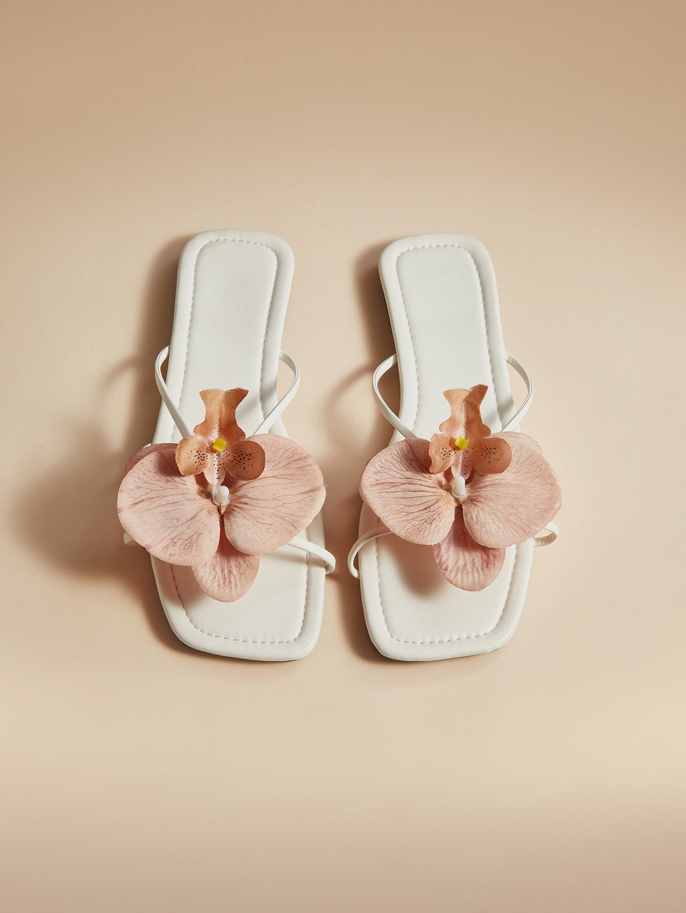 Brown women's flat slide sandals with floral applique strap and plant-inspired design, suitable for outdoor summer wear.