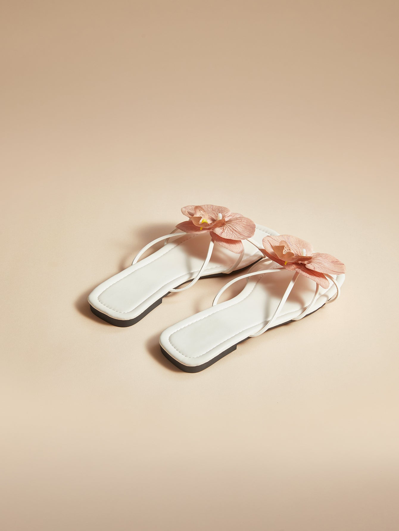 Brown women's flat slide sandals with floral applique strap and plant-inspired design, suitable for outdoor summer wear.