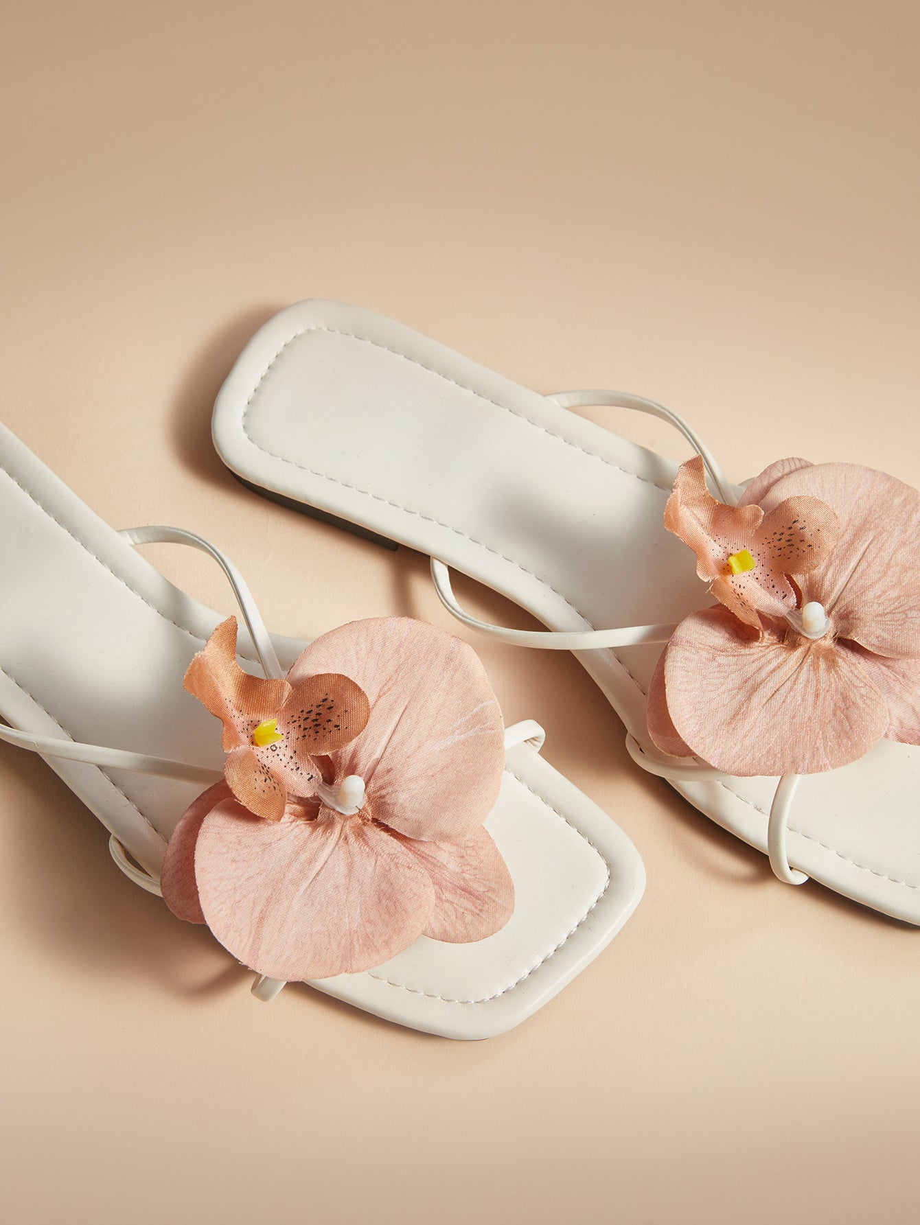 Brown women's flat slide sandals with floral applique strap and plant-inspired design, suitable for outdoor summer wear.