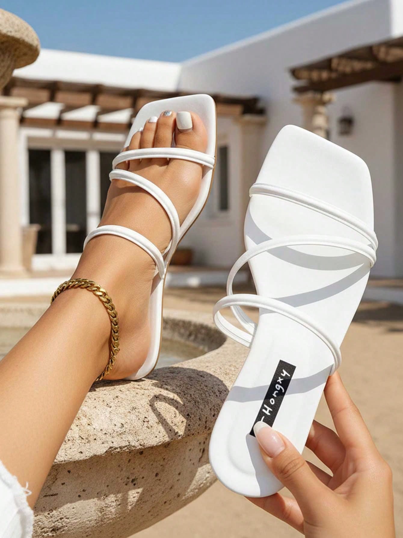 Women's slip-on flat slide sandals with bow tie decor, textured plain upper, and open toe.