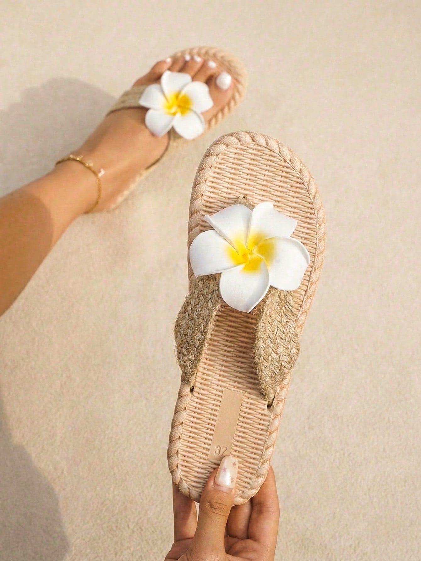 Women's flat woven slide sandals with open toe, featuring 3D flower and pearl appliques in an apricot and blue flower colorway, shown as casual vacation beach slippers.