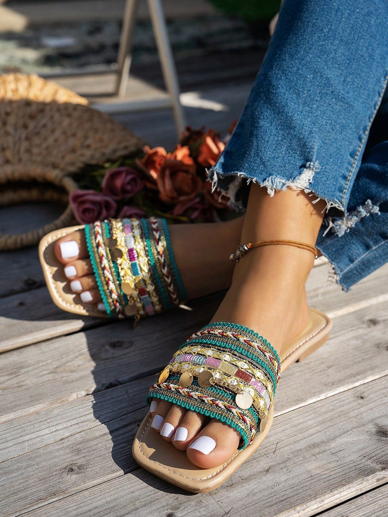 Pair of green women’s flat slide sandals with open toes, embroidered and beaded detailing, and fringe accents in a vacation style.