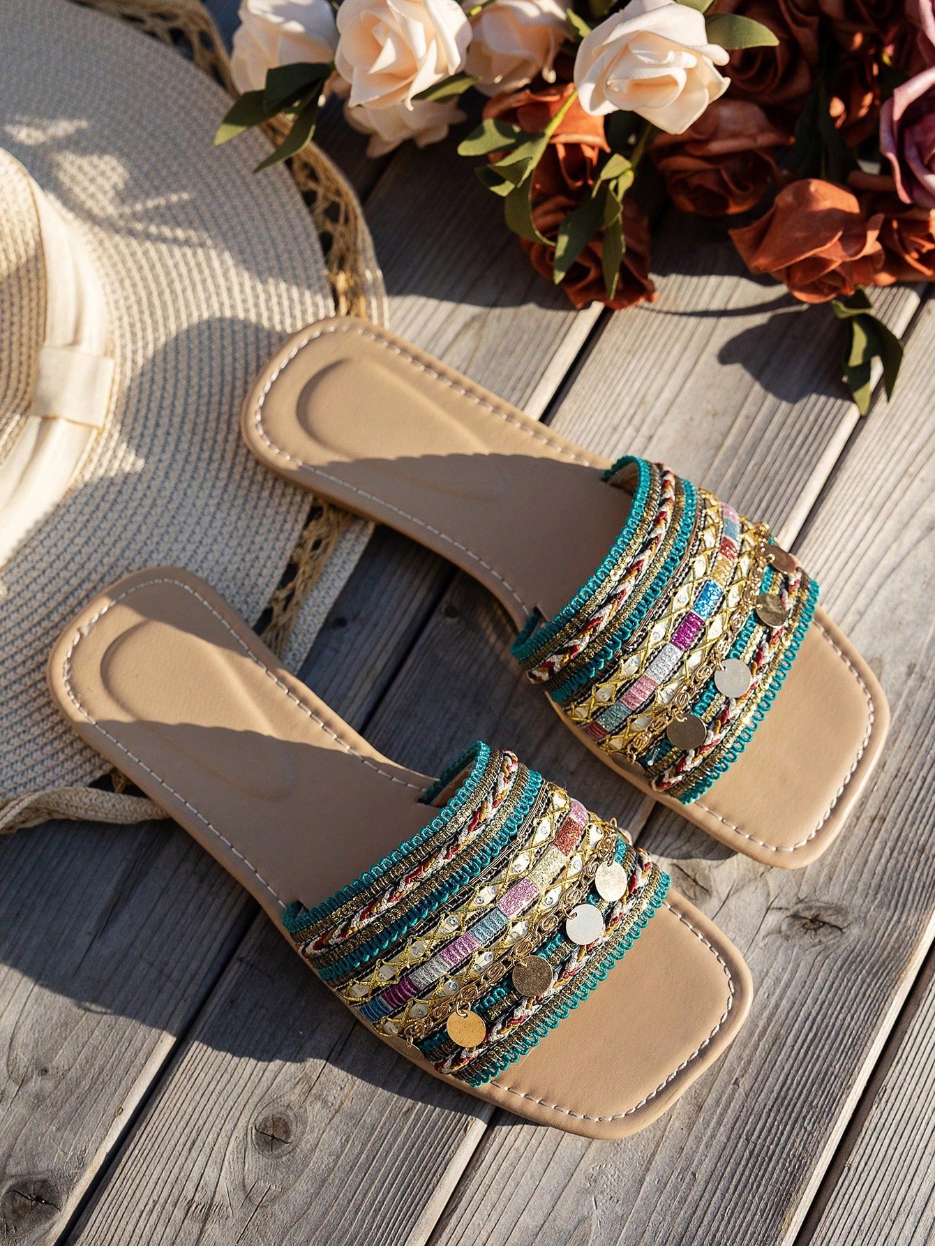 Pair of green women’s flat slide sandals with open toes, embroidered and beaded detailing, and fringe accents in a vacation style.