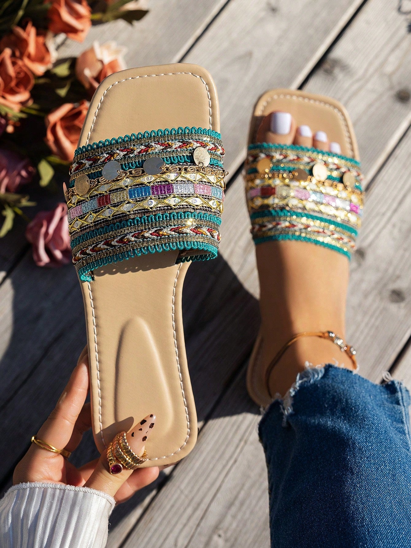 Pair of green women’s flat slide sandals with open toes, embroidered and beaded detailing, and fringe accents in a vacation style.