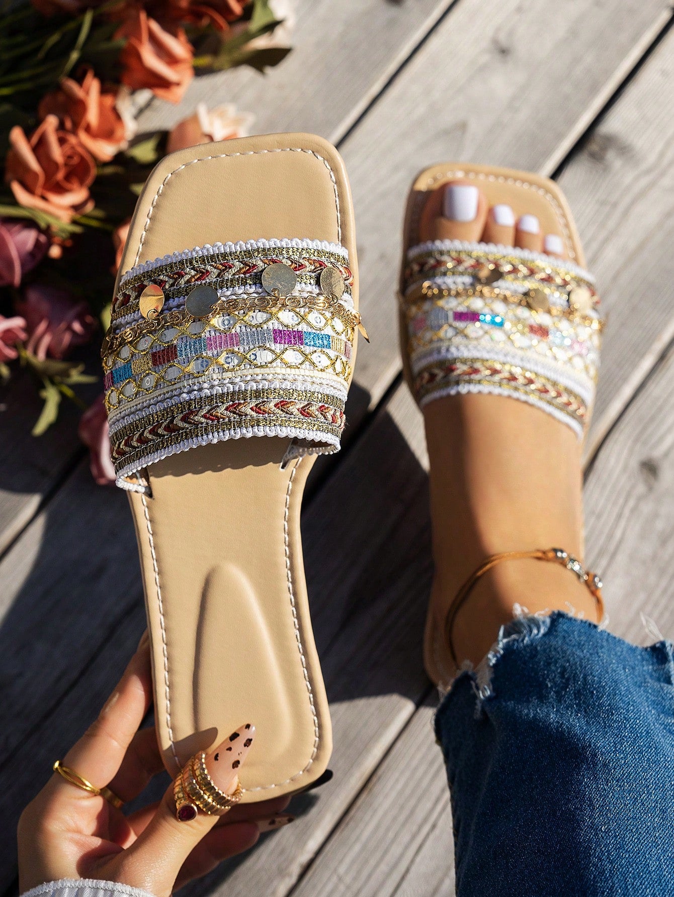Pair of green women’s flat slide sandals with open toes, embroidered and beaded detailing, and fringe accents in a vacation style.