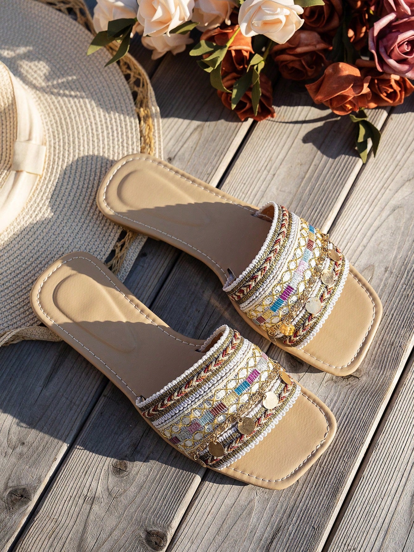 Pair of green women’s flat slide sandals with open toes, embroidered and beaded detailing, and fringe accents in a vacation style.