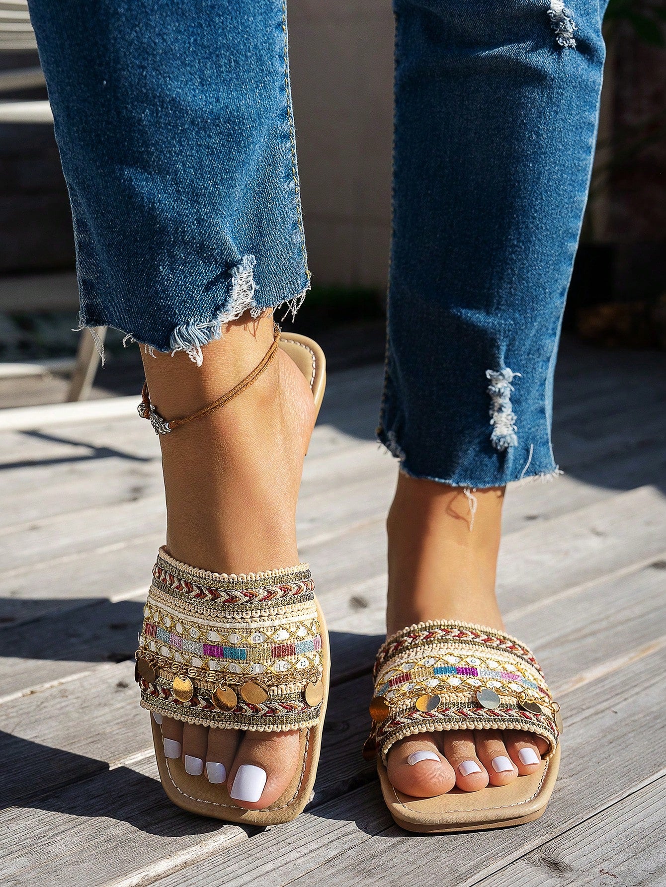 Pair of green women’s flat slide sandals with open toes, embroidered and beaded detailing, and fringe accents in a vacation style.