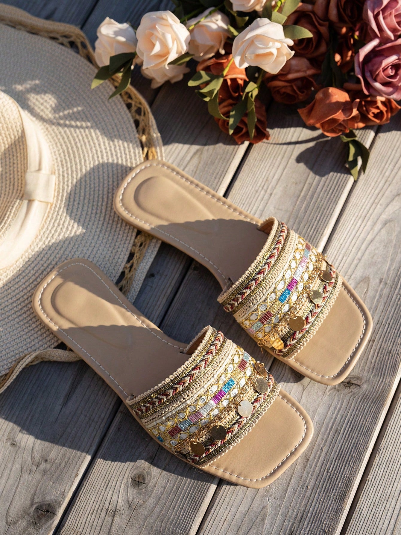 Pair of green women’s flat slide sandals with open toes, embroidered and beaded detailing, and fringe accents in a vacation style.