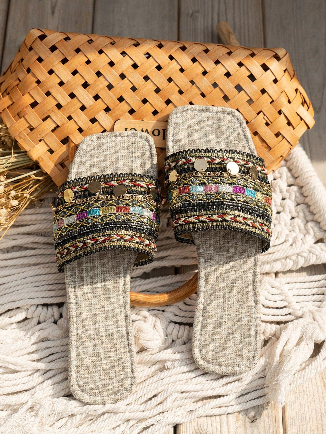 Pair of green women’s flat slide sandals with open toes, embroidered and beaded detailing, and fringe accents in a vacation style.