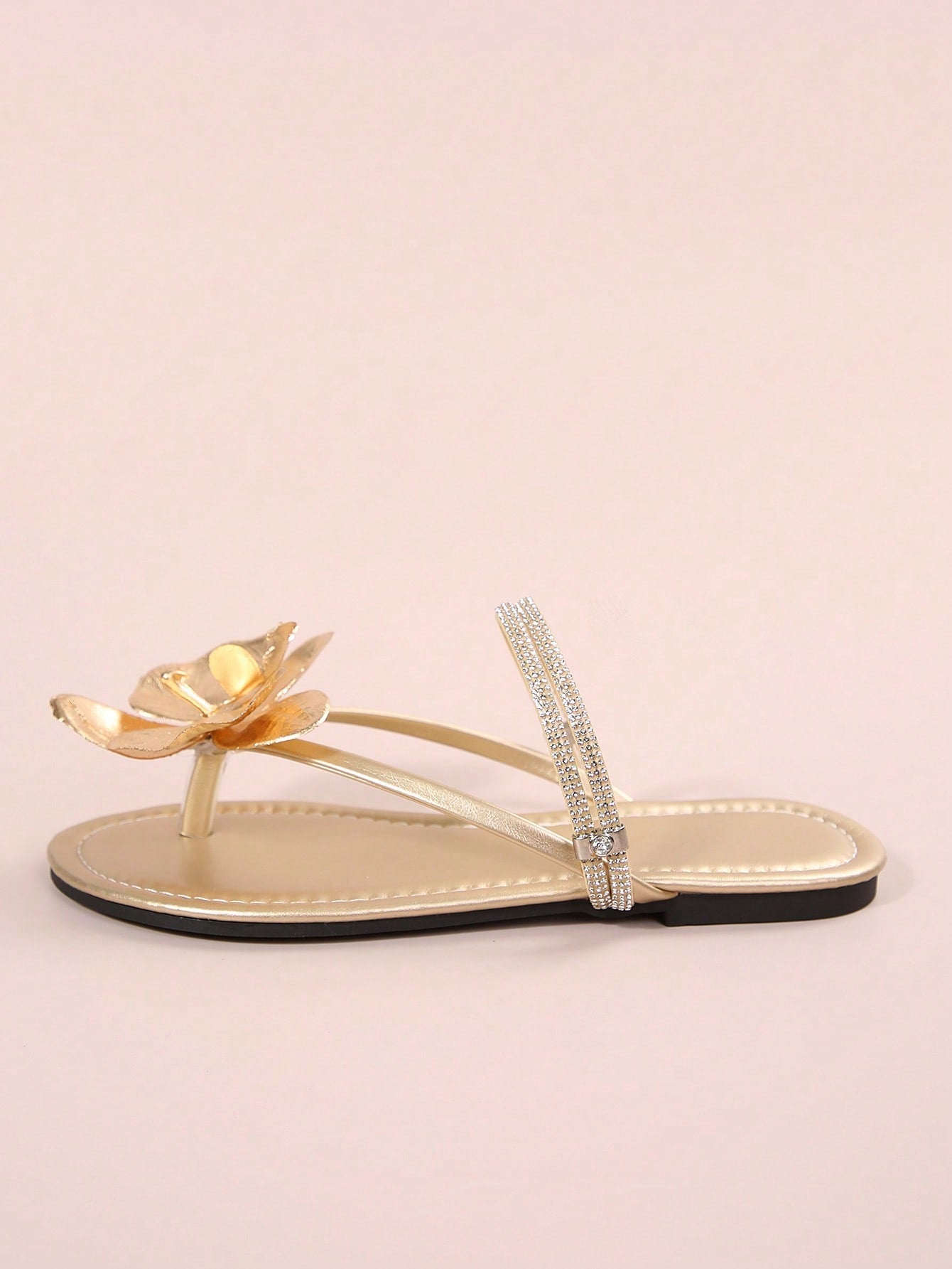 Women's flat slide sandals with open toe, floral applique detail, and criss-cross straps, shown as casual vacation-style summer footwear.