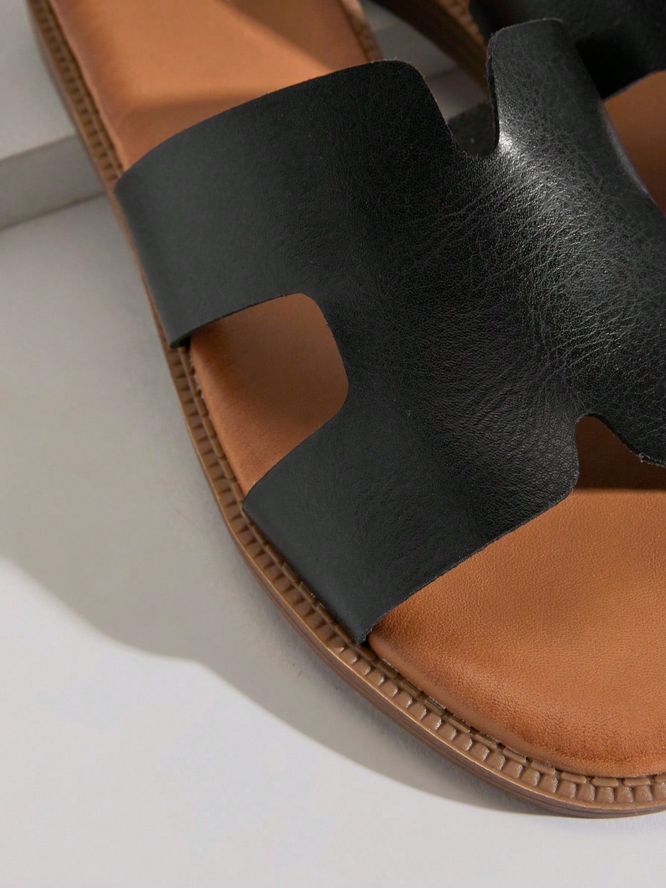 Women's flat slide sandals with supportive PU midsole, harness-style cutout detail, and open toe design.