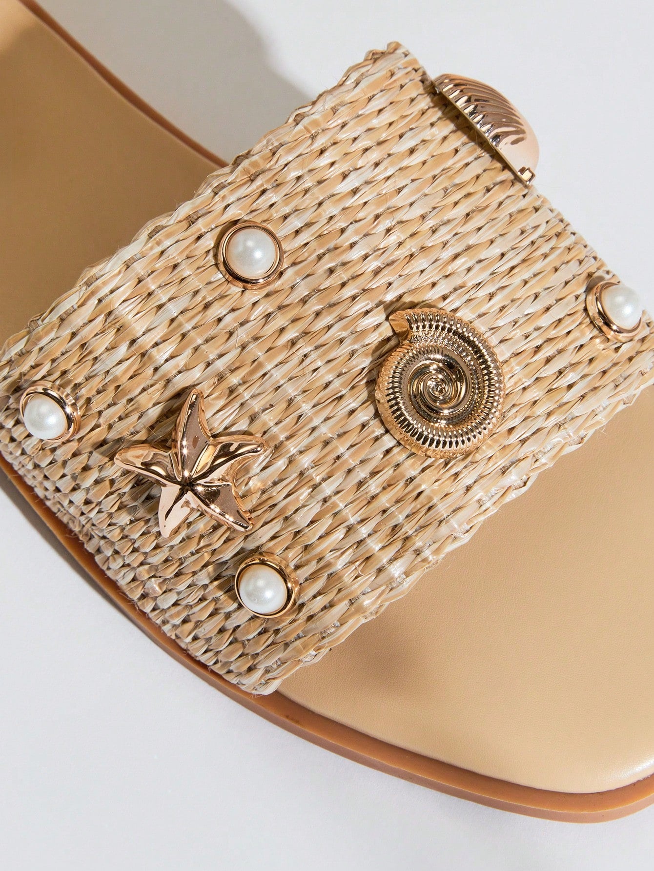 Women's slip-on flat slide sandals with open toe, woven one-band upper, and seashell and pearl ornaments in a marine life-inspired design.