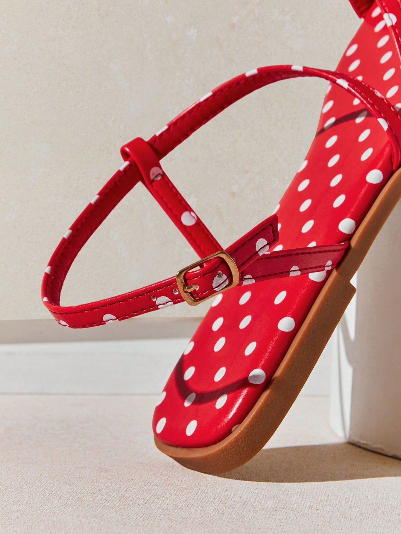 Women's flat open-toe sandals featuring a buckle detail and PU leather construction with a flat sole.
