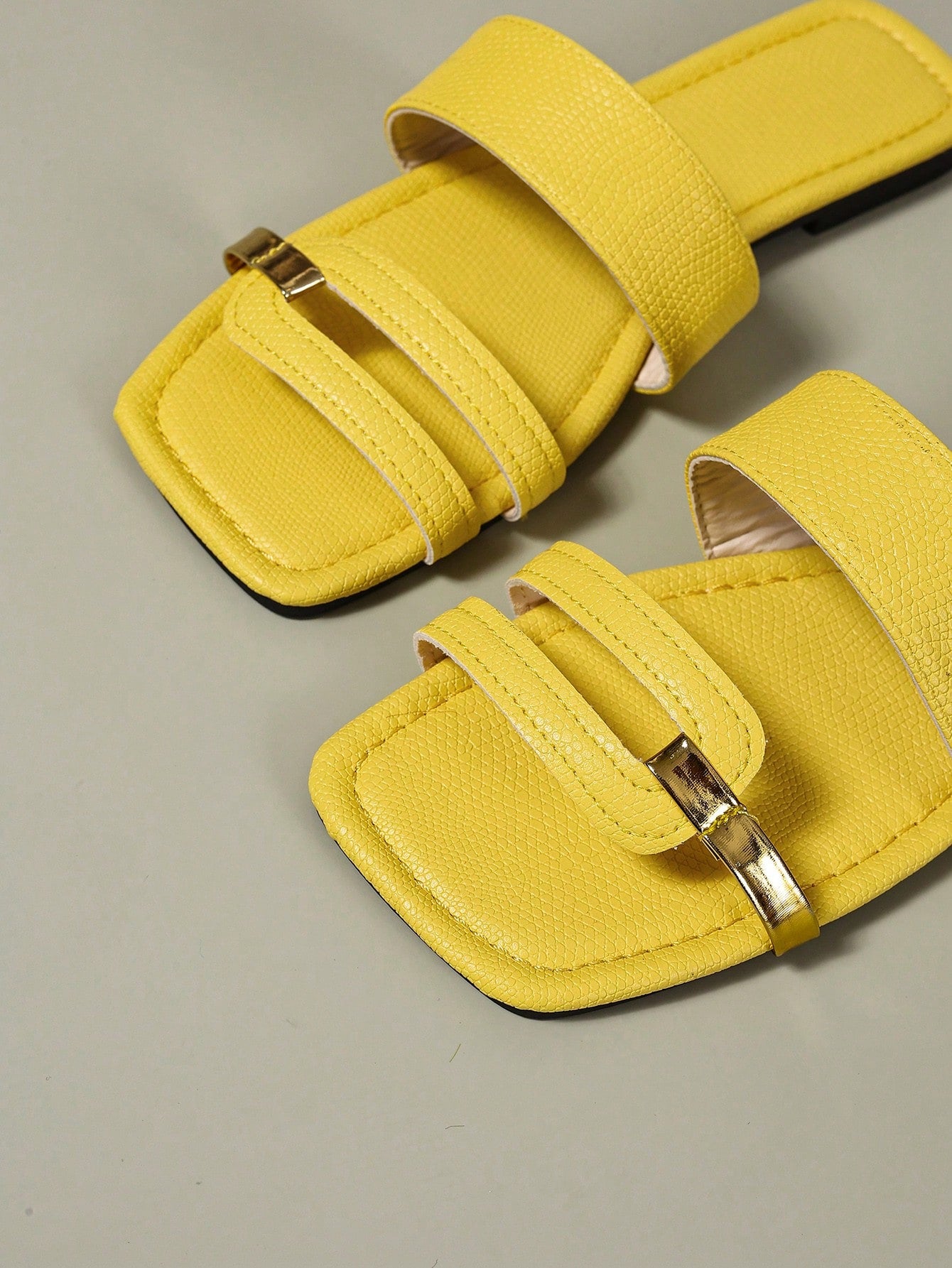 Women's yellow open-toe flat slide sandals featuring a cut-out design and textured plain pattern for casual beach and daily wear.
