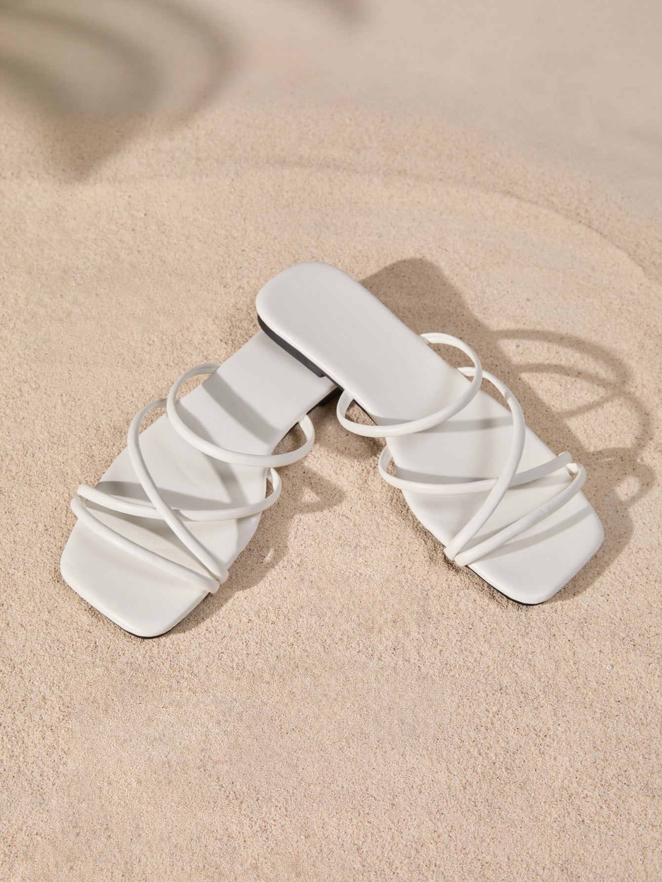 Women's white flat gladiator sandals with square toe, criss-cross straps, and toe post detail