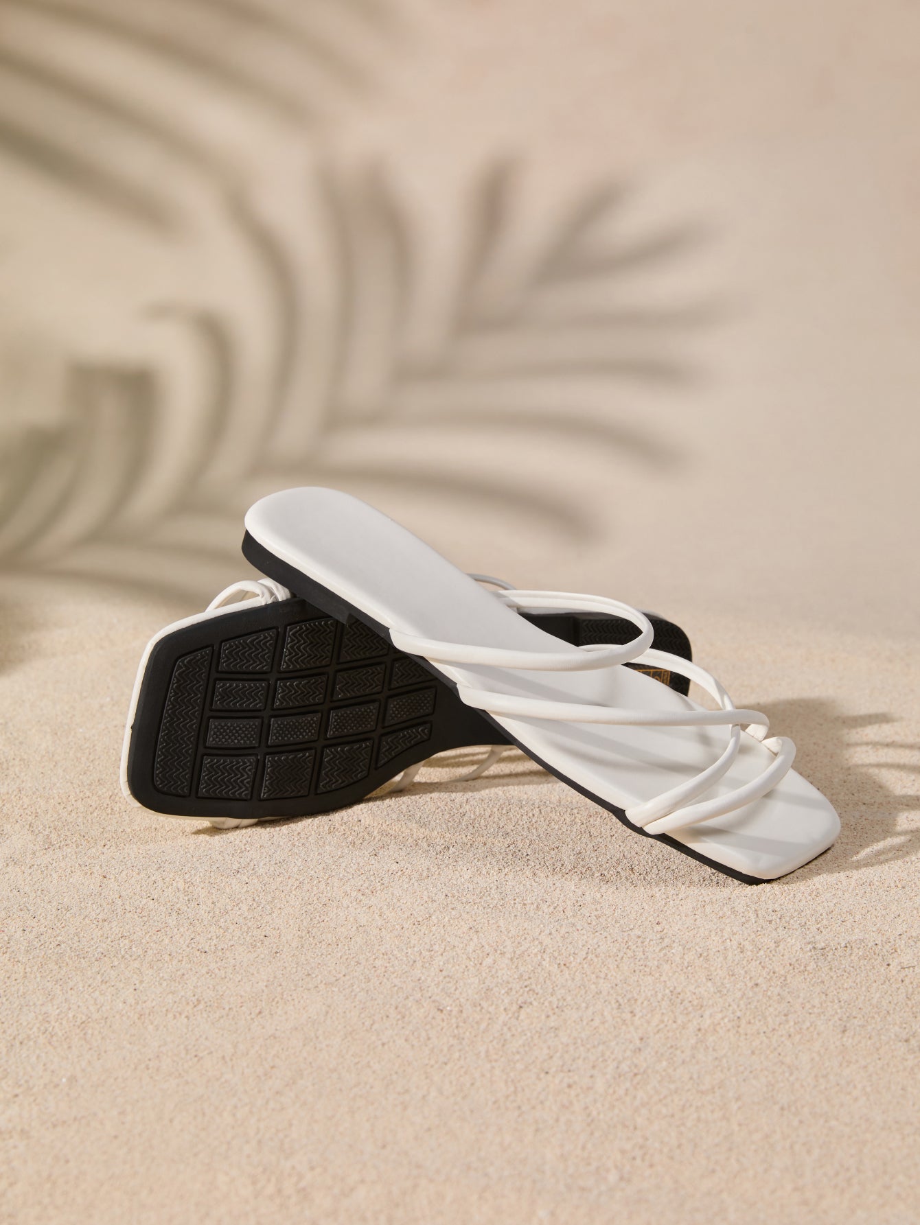 Women's white flat gladiator sandals with square toe, criss-cross straps, and toe post detail