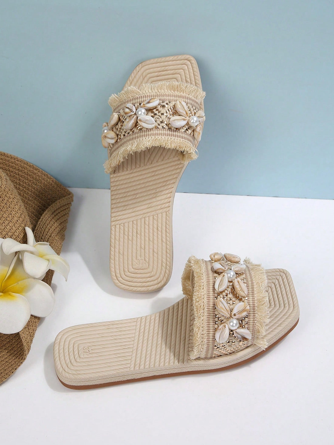 Women's open-toe strappy flat sandals with tasseled upper, seashell-inspired decoration, and rhinestone detail, designed for lightweight, comfortable beach and casual indoor or outdoor wear.