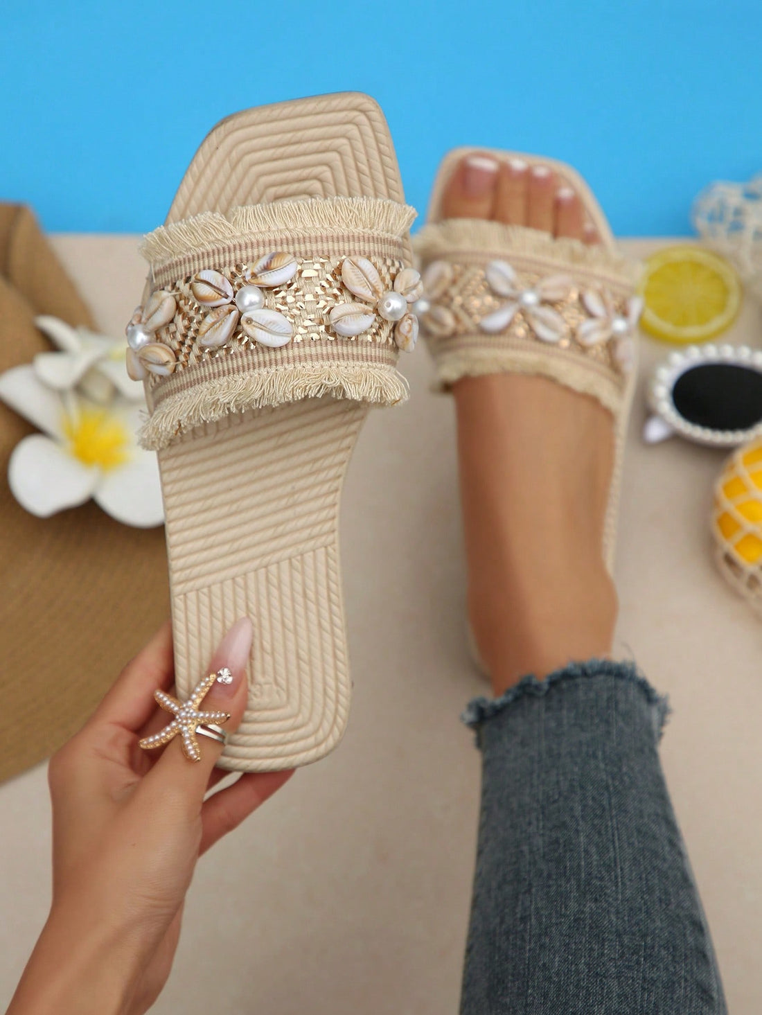 Women's open-toe strappy flat sandals with tasseled upper, seashell-inspired decoration, and rhinestone detail, designed for lightweight, comfortable beach and casual indoor or outdoor wear.