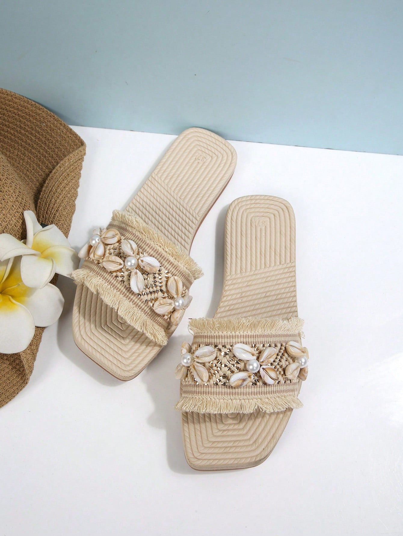 Women's open-toe strappy flat sandals with tasseled upper, seashell-inspired decoration, and rhinestone detail, designed for lightweight, comfortable beach and casual indoor or outdoor wear.