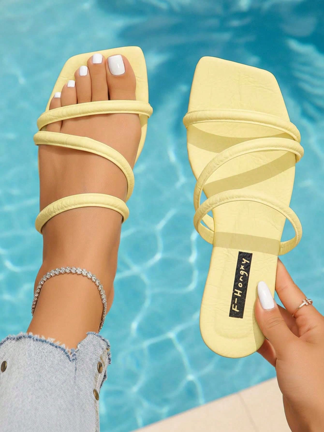 Women's slip-on flat slide sandals with bow tie decor, textured plain upper, and open toe.