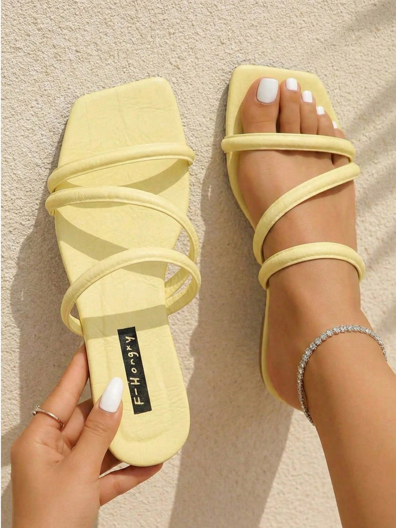Women's slip-on flat slide sandals with bow tie decor, textured plain upper, and open toe.