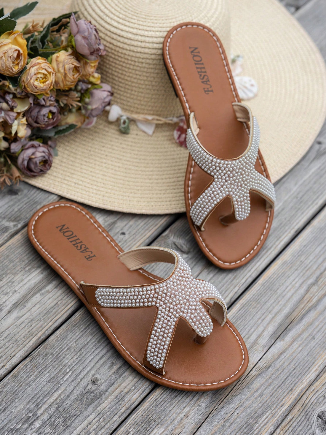 Women's brown flat thong sandals with starfish and pearl detail, criss-cross straps, and toe post design for beach casual summer wear.