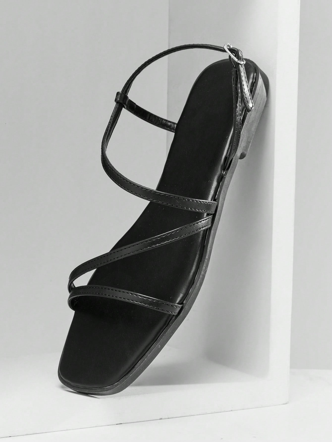 Women's flat open-toe sandals featuring a buckle detail and PU leather construction with a flat sole.