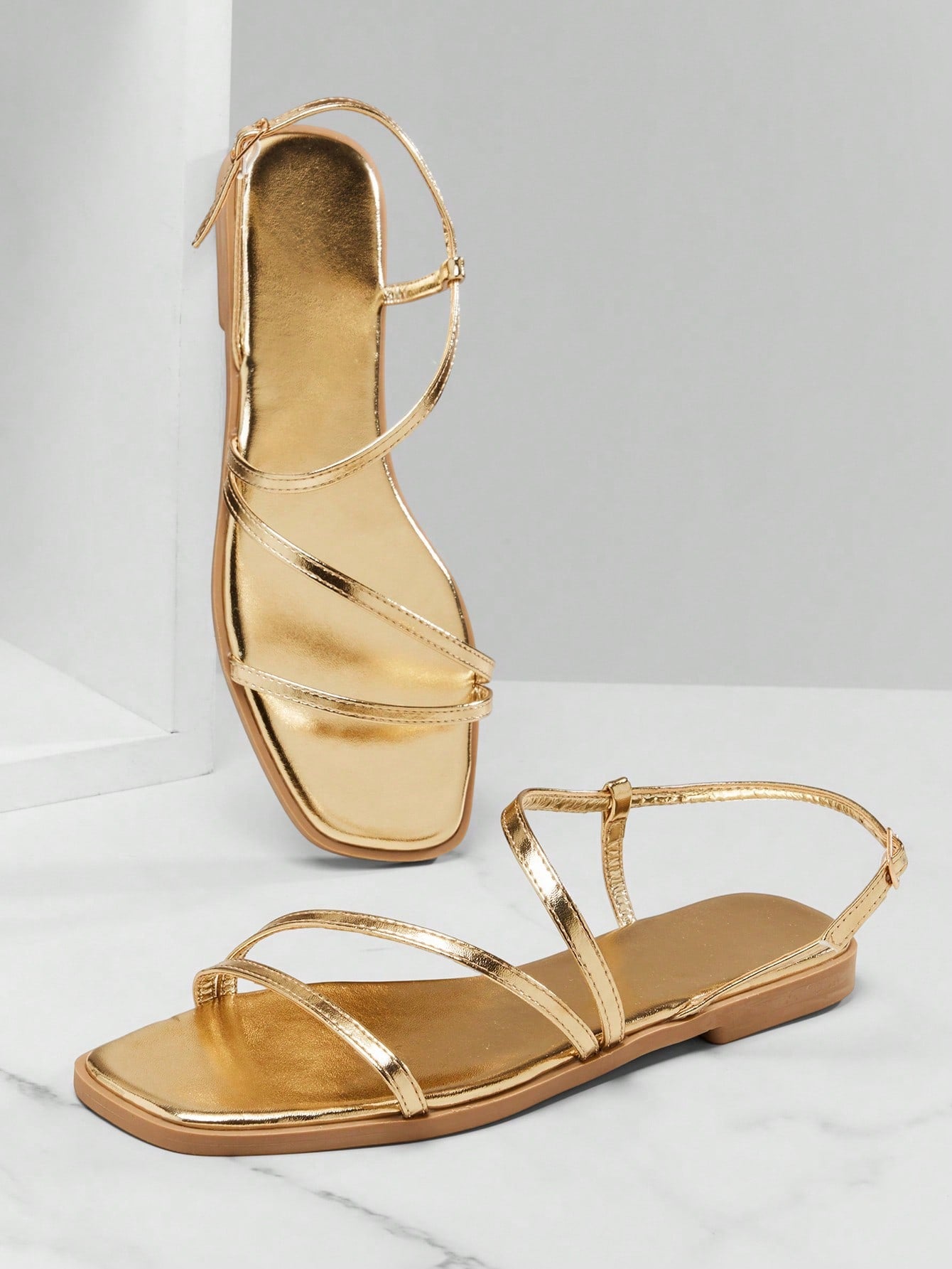 Women's flat open-toe sandals featuring a buckle detail and PU leather construction with a flat sole.