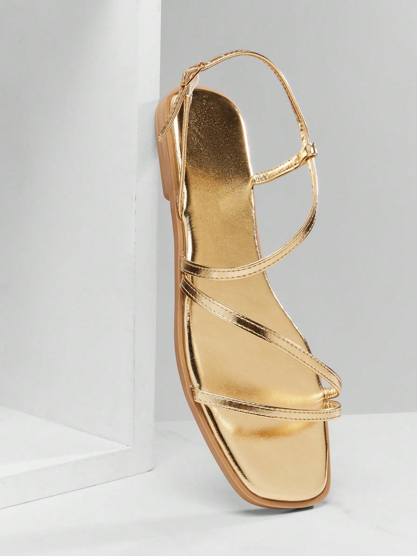 Women's flat open-toe sandals featuring a buckle detail and PU leather construction with a flat sole.
