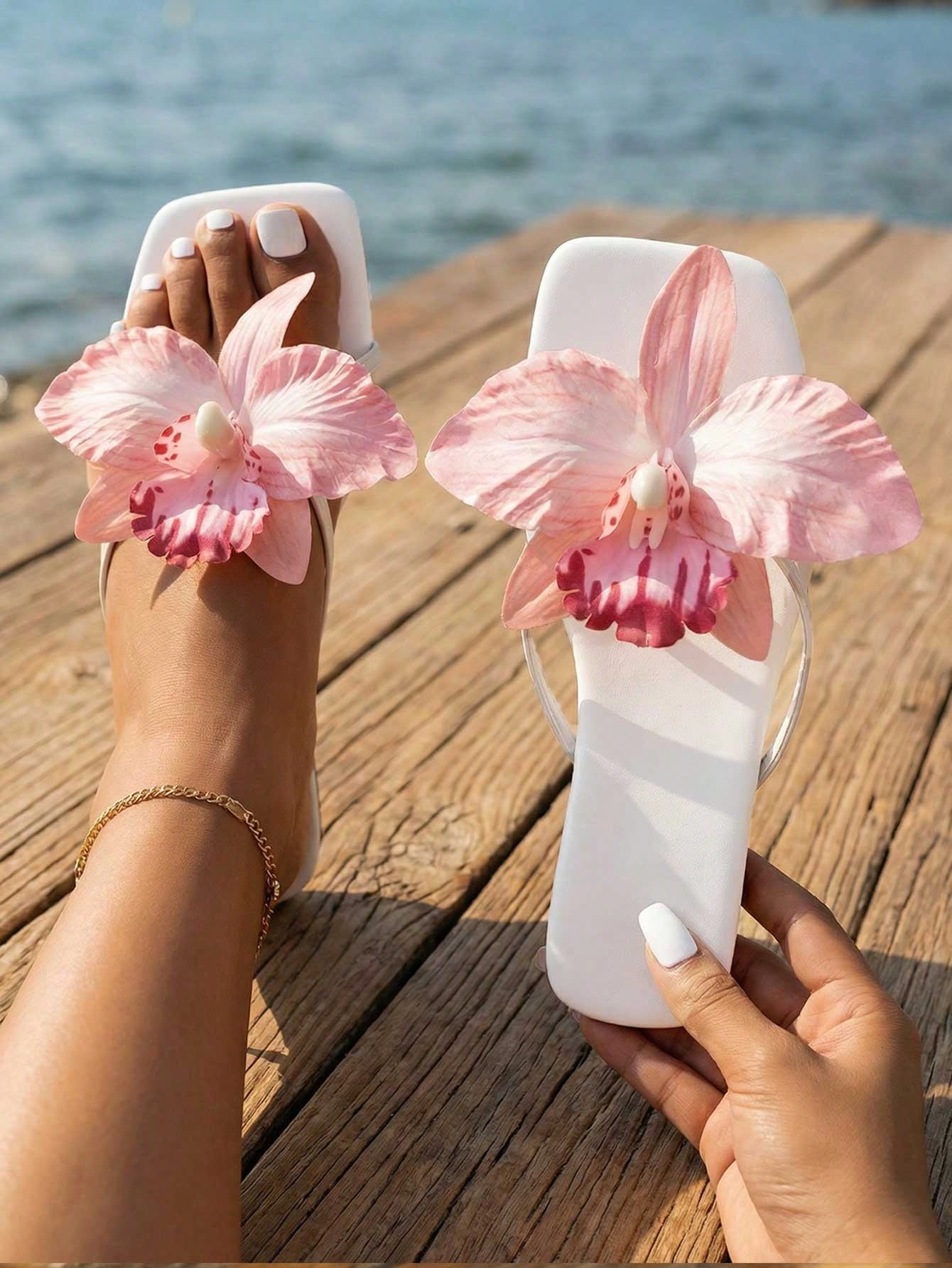 Women's white open-toe slide flat sandals with pink flower applique on the strap