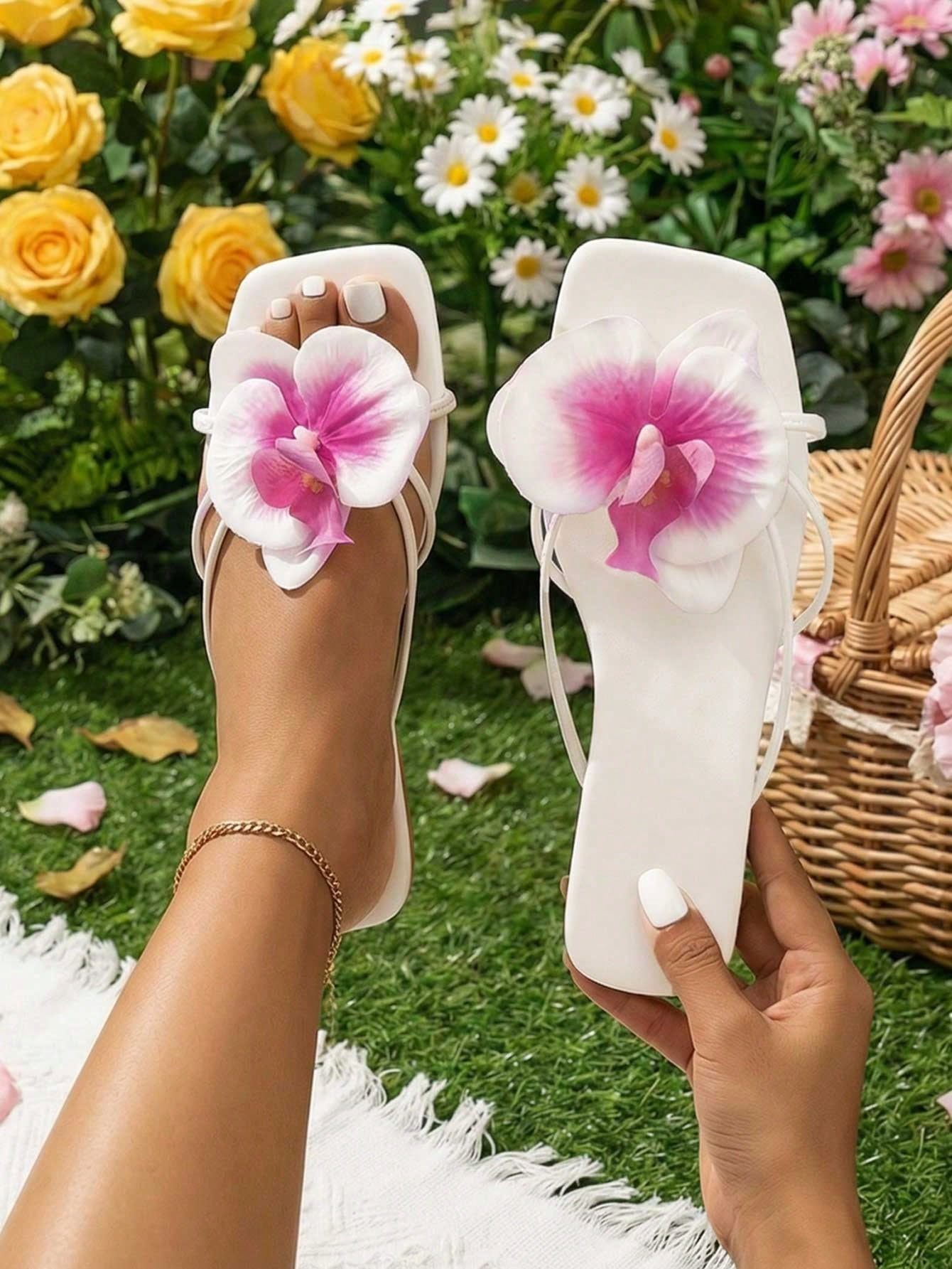 Women's flat woven slide sandals with open toe, featuring 3D flower and pearl appliques in an apricot and blue flower colorway, shown as casual vacation beach slippers.