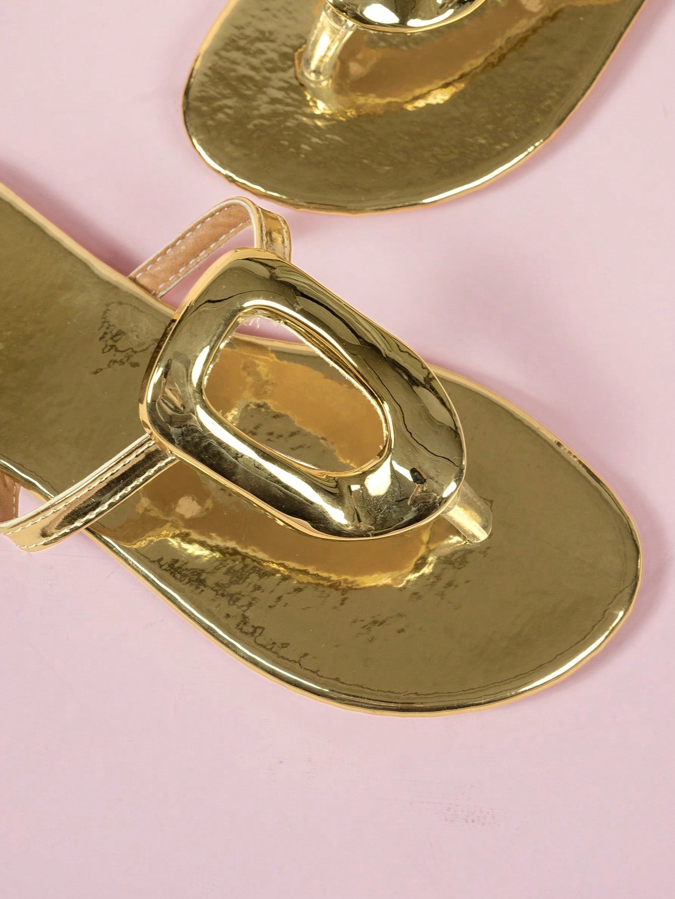 Women's gold wide-strap slip-on beach sandals with buckle detail, open toe, and flat sole.