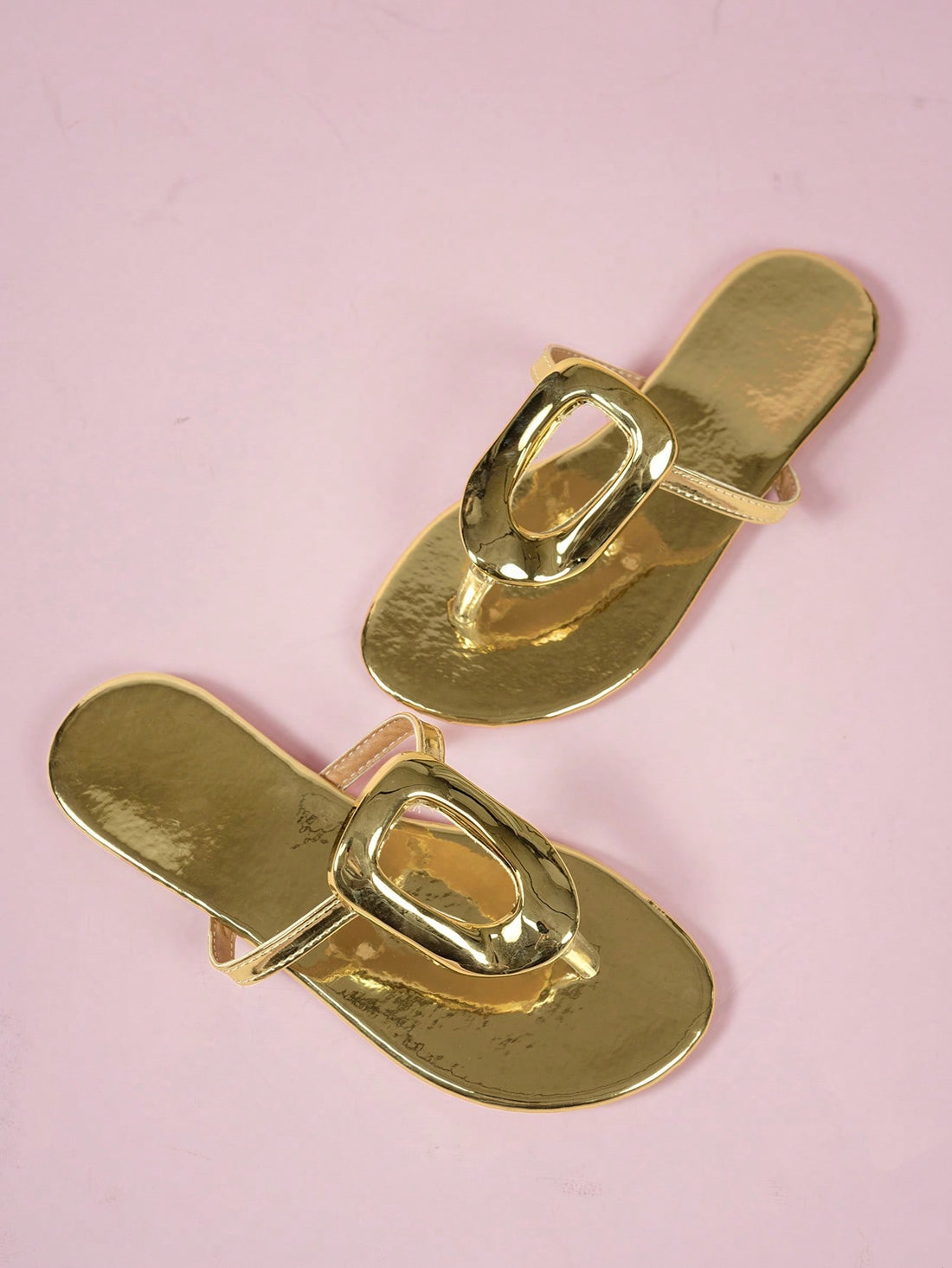 Women's gold wide-strap slip-on beach sandals with buckle detail, open toe, and flat sole.