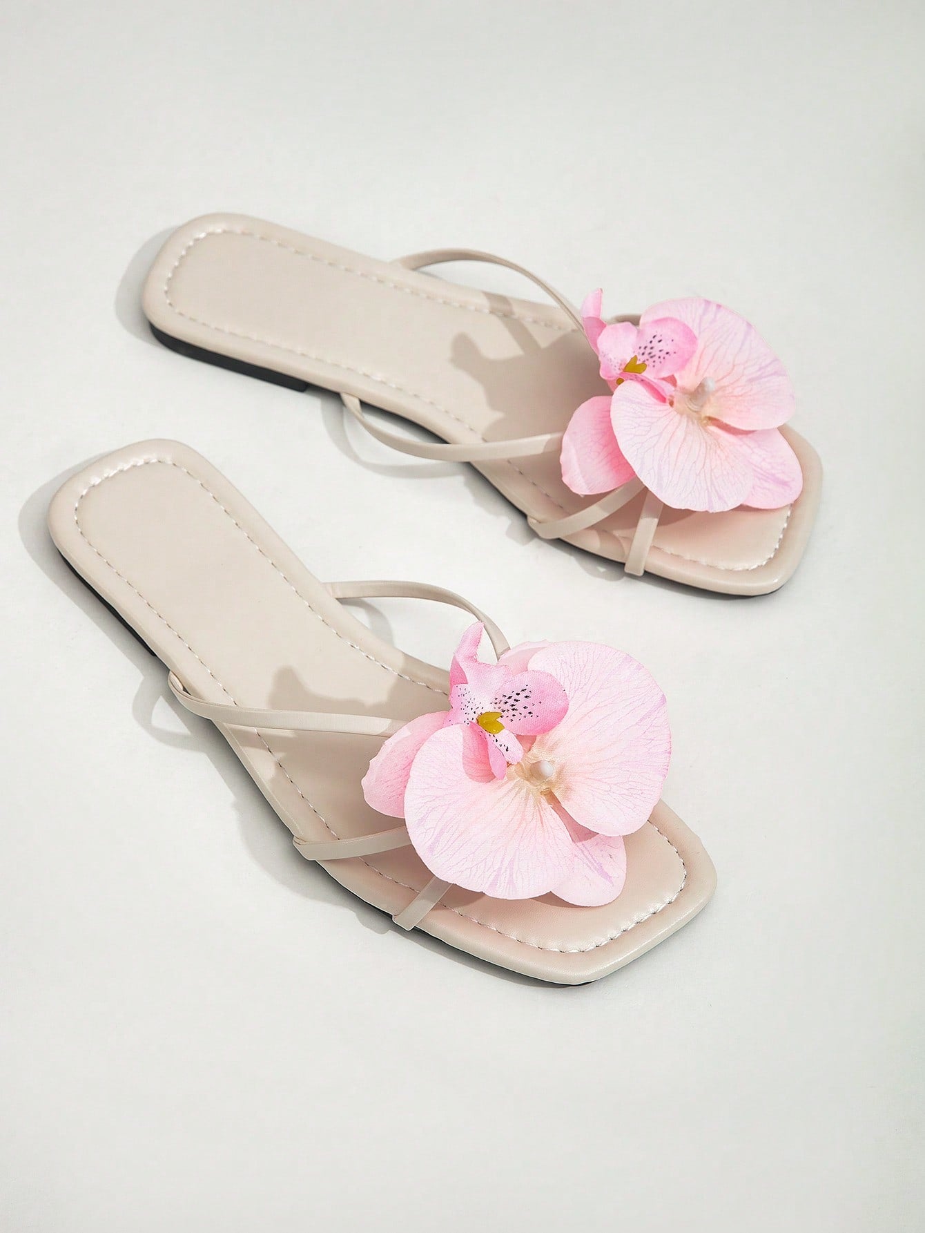 Wide fit women's beige flat thong sandals with butterfly orchid appliqué decor and open toe, suitable for beach, vacation, home, and casual everyday wear.