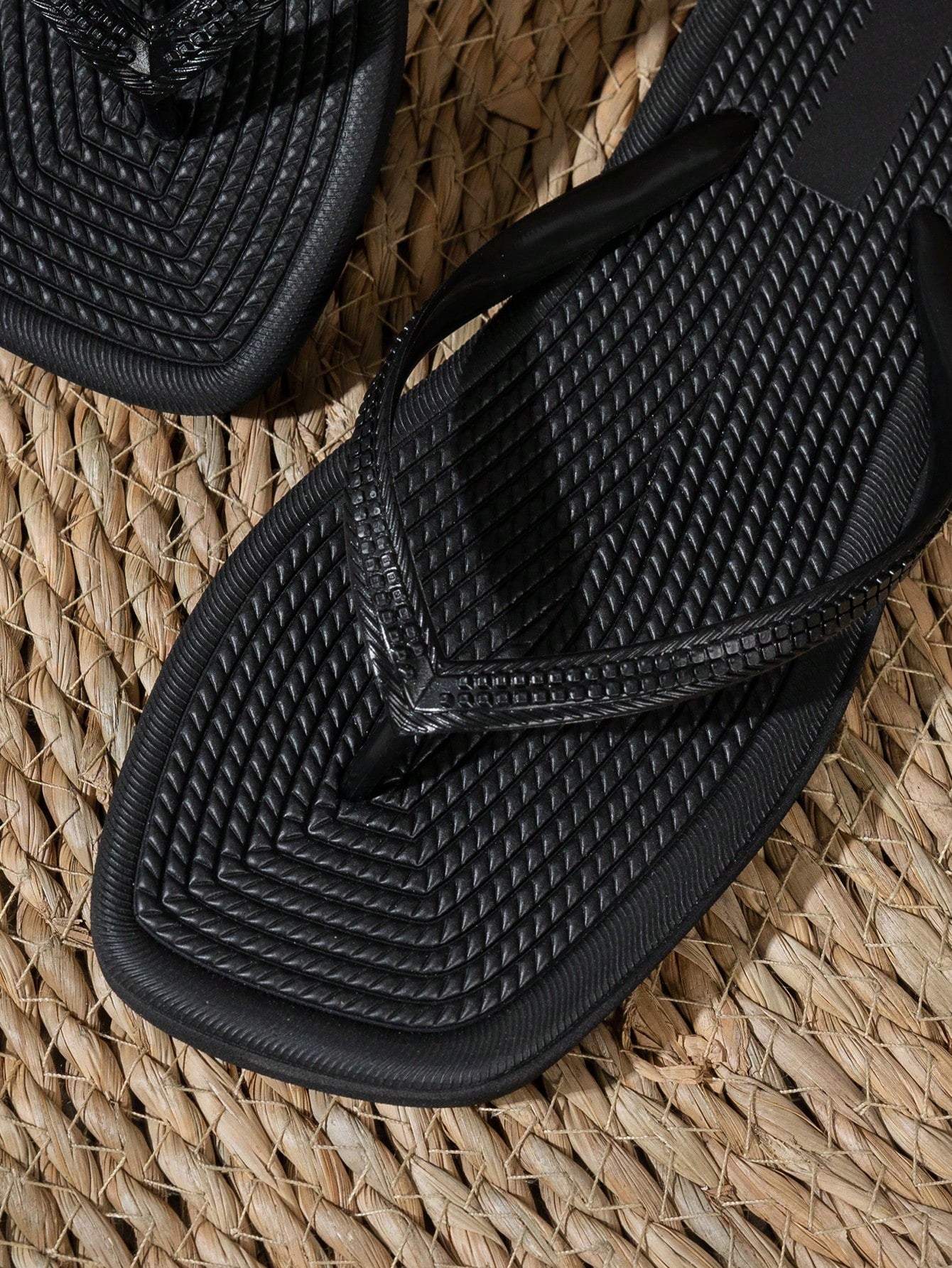 Women's solid color flip flops with open-toe design, flat sole, and cut-out details, suitable for casual indoor or outdoor wear at the beach or pool.