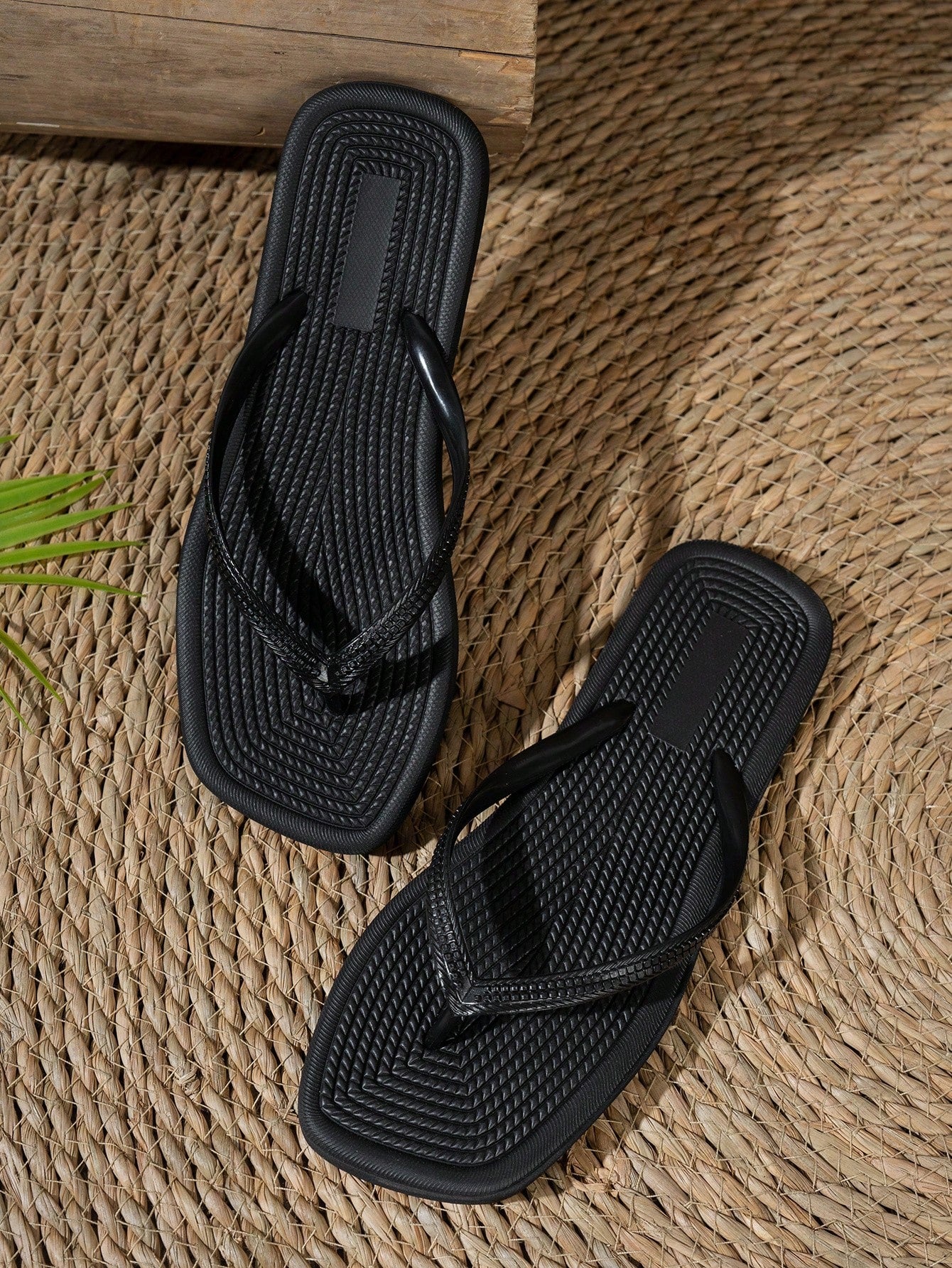 Women's solid color flip flops with open-toe design, flat sole, and cut-out details, suitable for casual indoor or outdoor wear at the beach or pool.