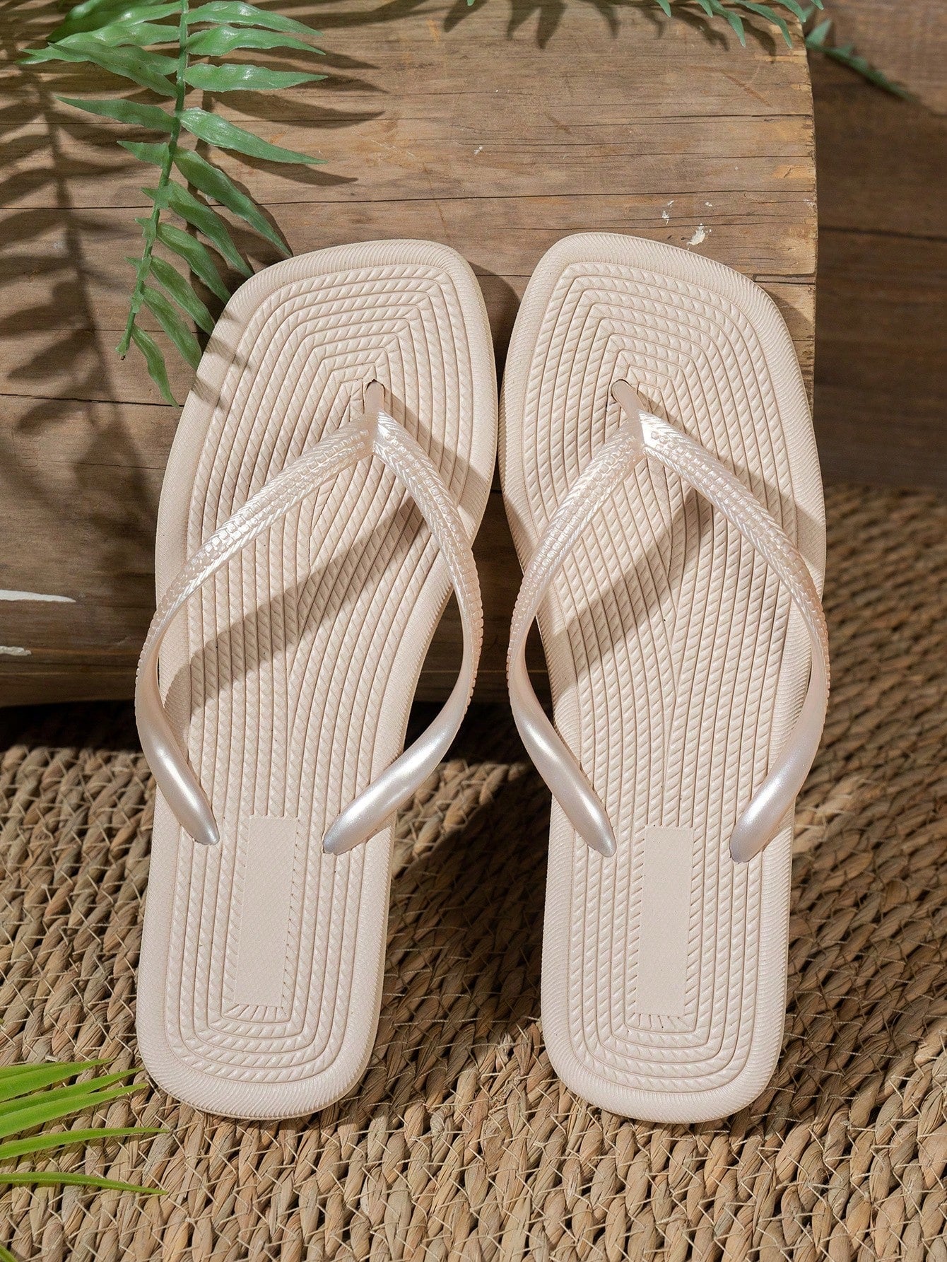 Women's solid color flip flops with open-toe design, flat sole, and cut-out details, suitable for casual indoor or outdoor wear at the beach or pool.