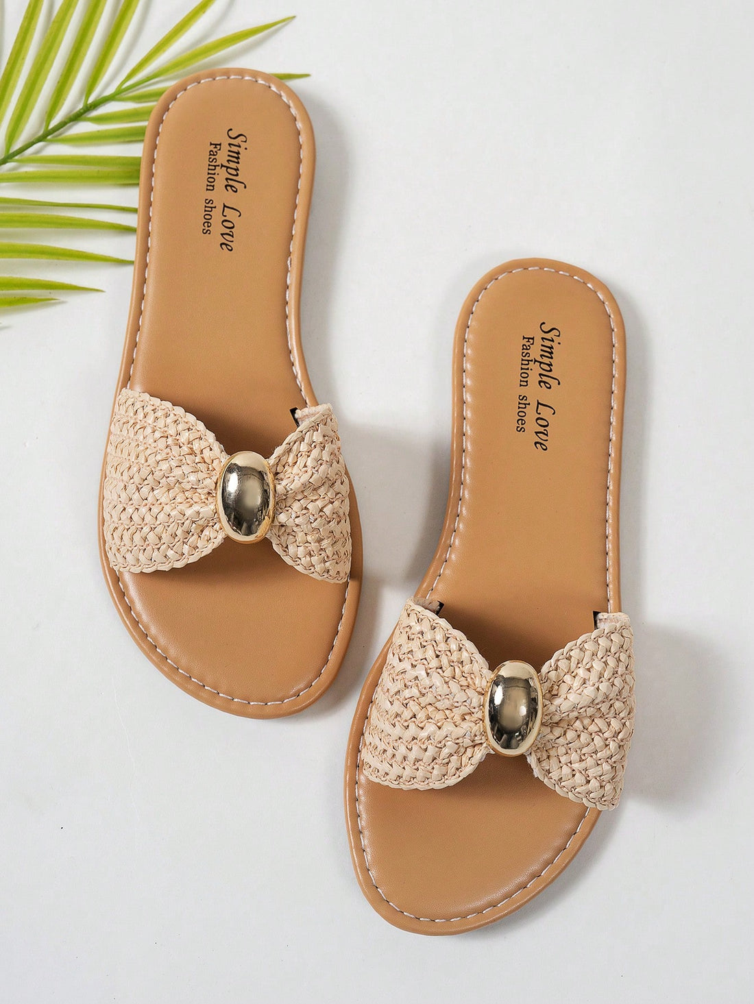 Women's brown straw woven flat slide sandals with bowknot metal decor, braided open-toe strap, and round toe.