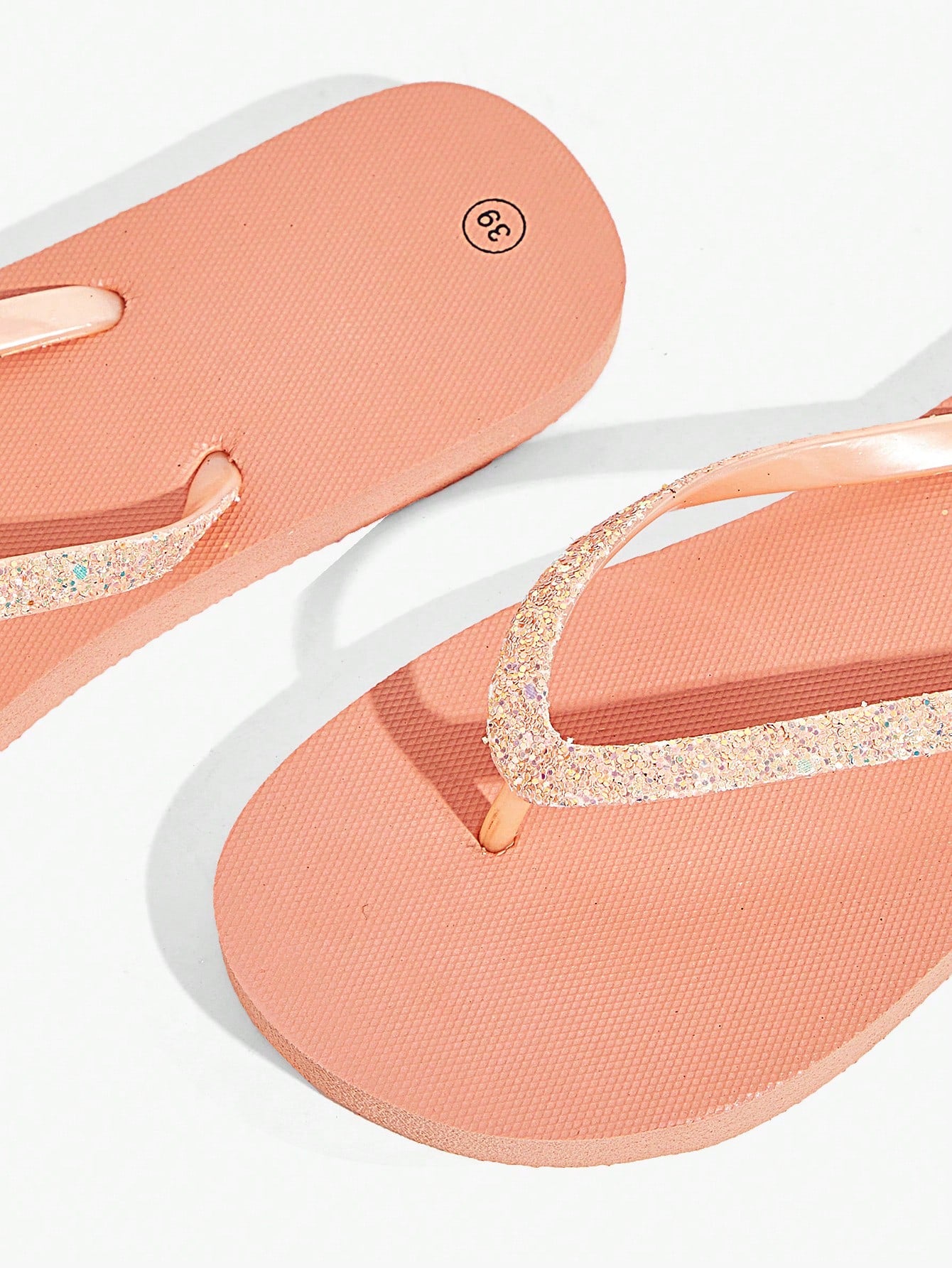 Pair of women’s apricot flat flip-flops with a glitter upper and plain design, suitable for beach, outdoor, home, and vacation wear.