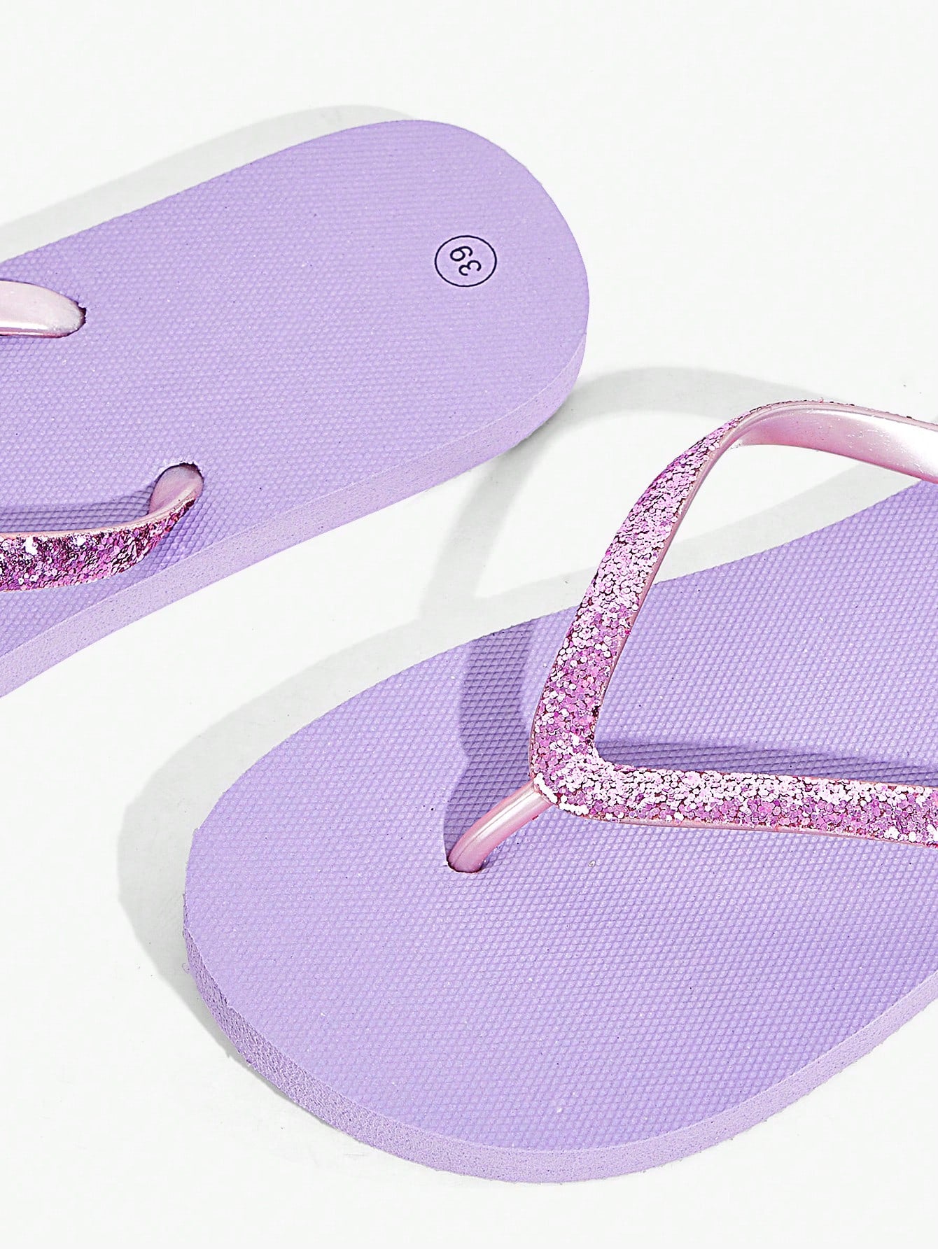 Pair of women’s apricot flat flip-flops with a glitter upper and plain design, suitable for beach, outdoor, home, and vacation wear.