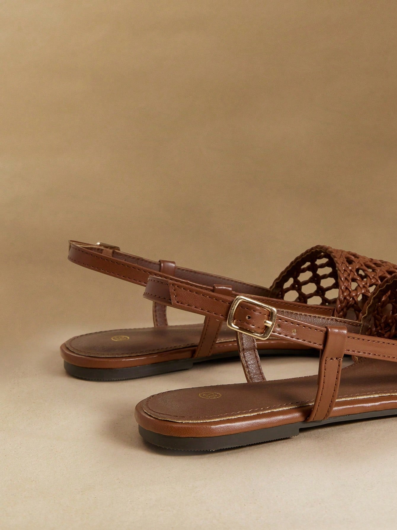 Women's flat gladiator sandals featuring a hollow-out multi-strap woven design and ankle strap style, with striped pattern and casual beach vacation look.