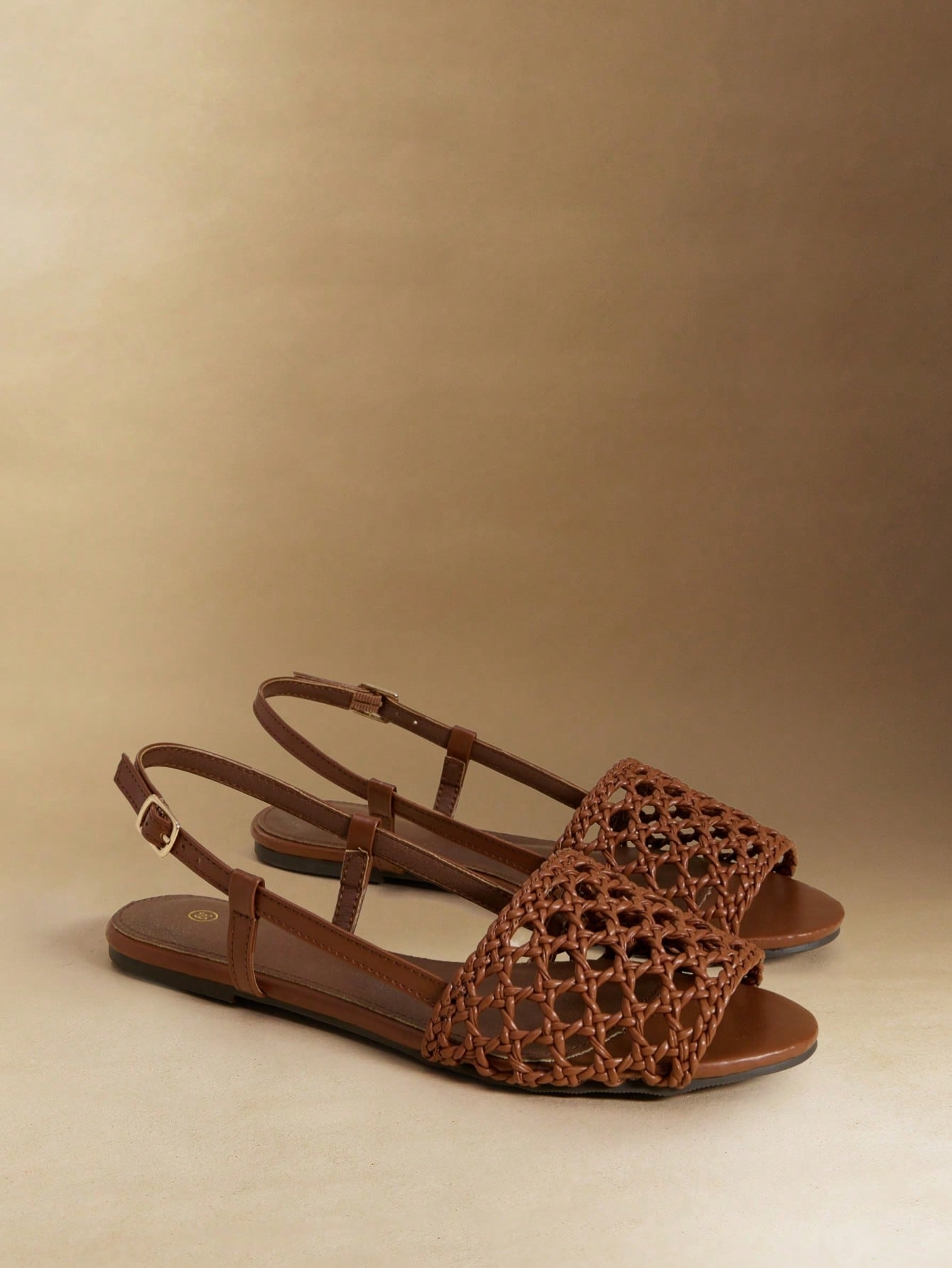 Women's flat gladiator sandals featuring a hollow-out multi-strap woven design and ankle strap style, with striped pattern and casual beach vacation look.