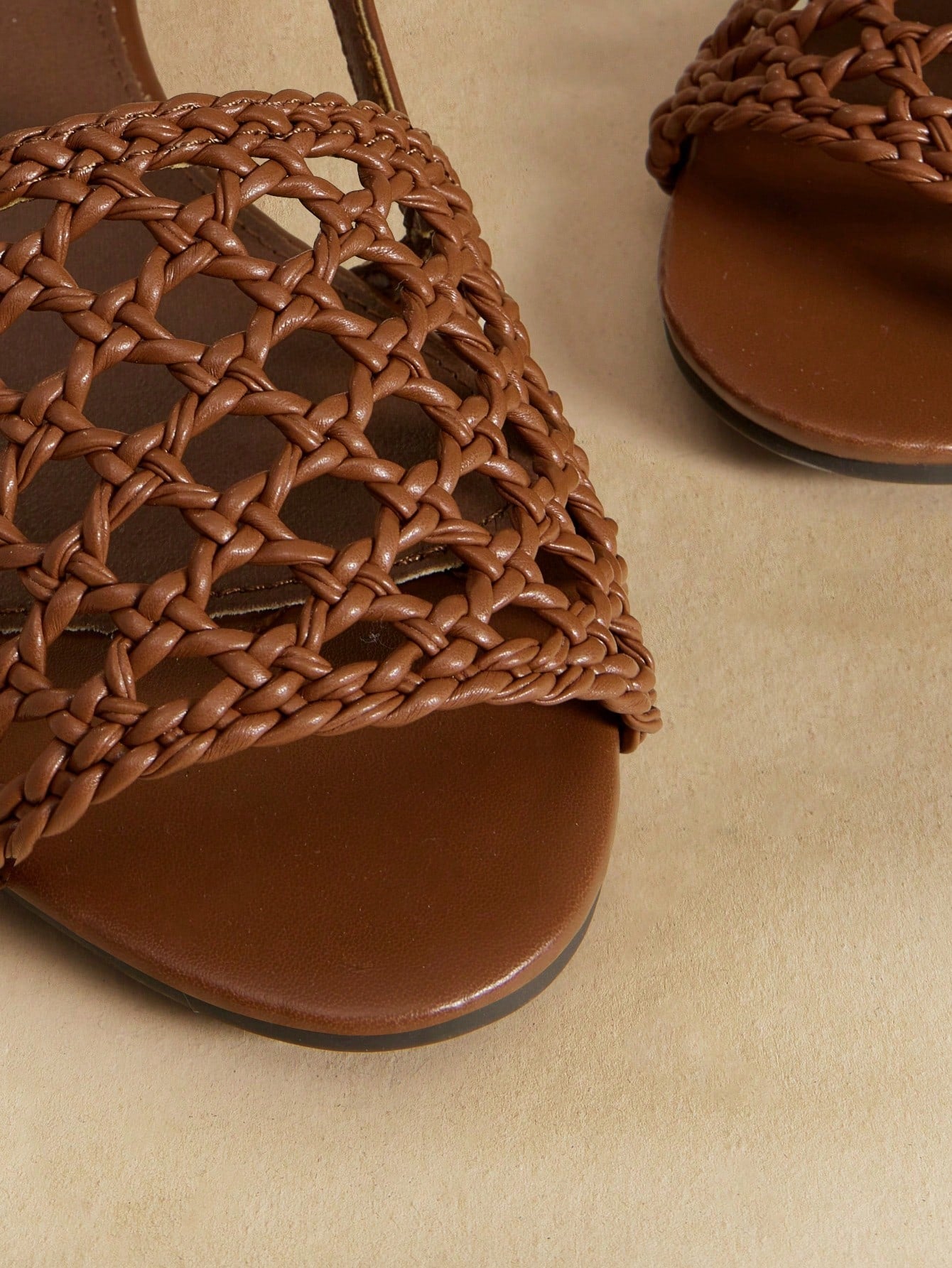 Women's flat gladiator sandals featuring a hollow-out multi-strap woven design and ankle strap style, with striped pattern and casual beach vacation look.