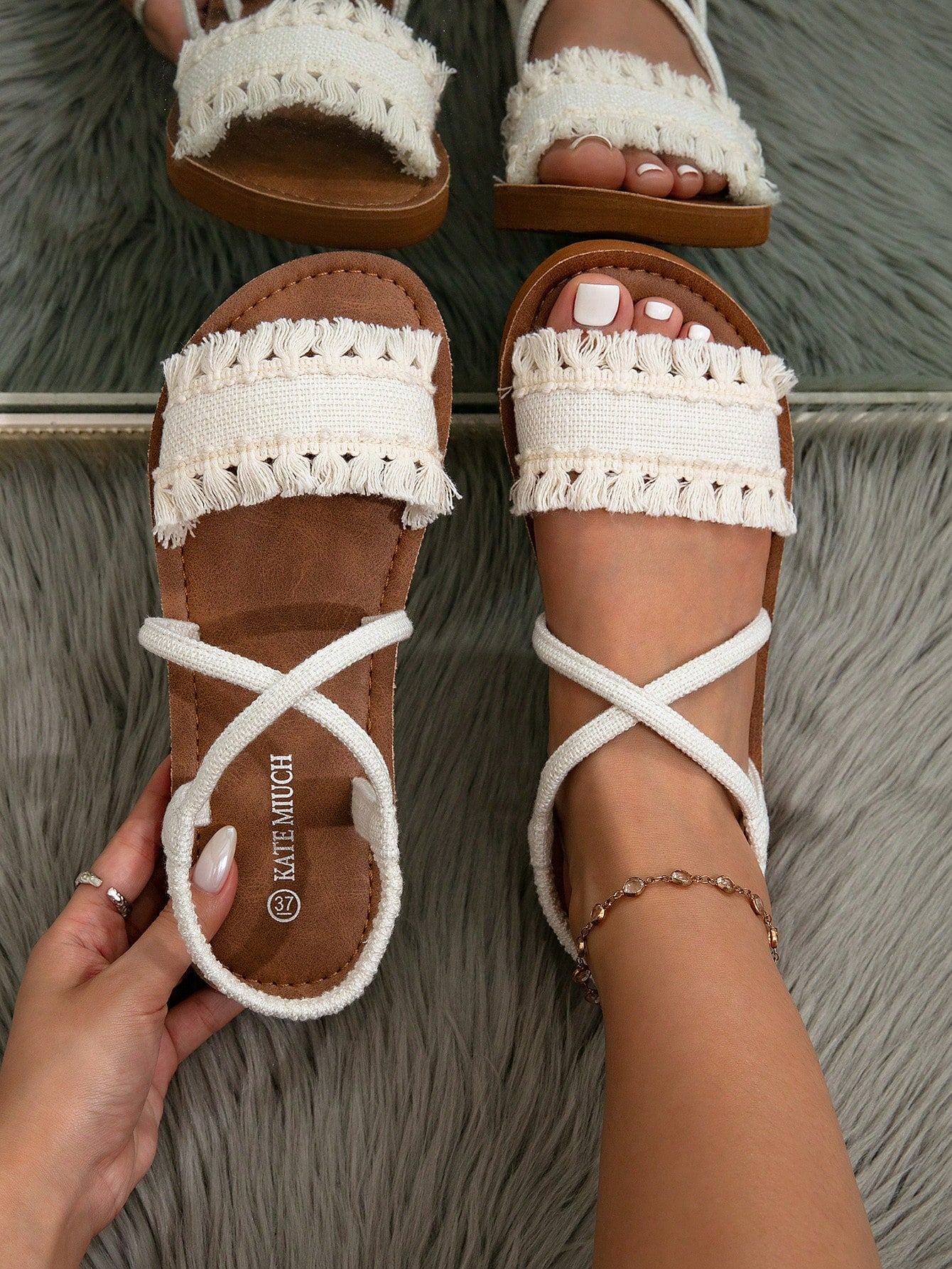Women's flat slide sandals with ruched fabric, bow accent, and fringe detail, suitable for outdoor vacation wear.