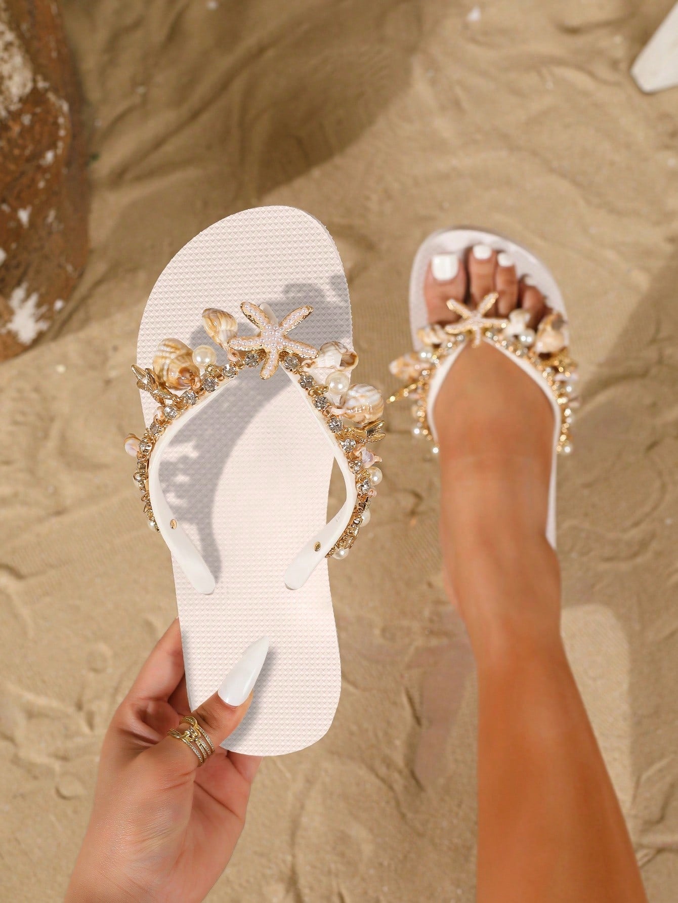 Women’s fashion flip flops with thong strap, beaded shell chain decoration, and removable decor chain detail, designed with a soft flat sole for beach and vacation use.