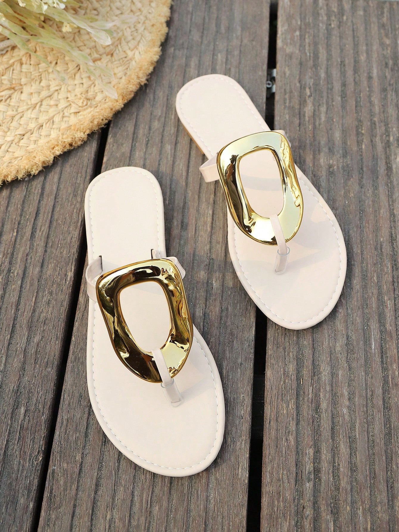 Women’s gold flat slide sandals with open toe post design and metal buckle detail, shown as fashionable outdoor summer footwear.