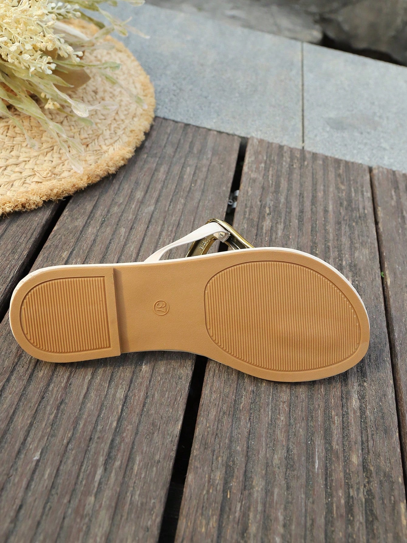 Women’s gold flat slide sandals with open toe post design and metal buckle detail, shown as fashionable outdoor summer footwear.